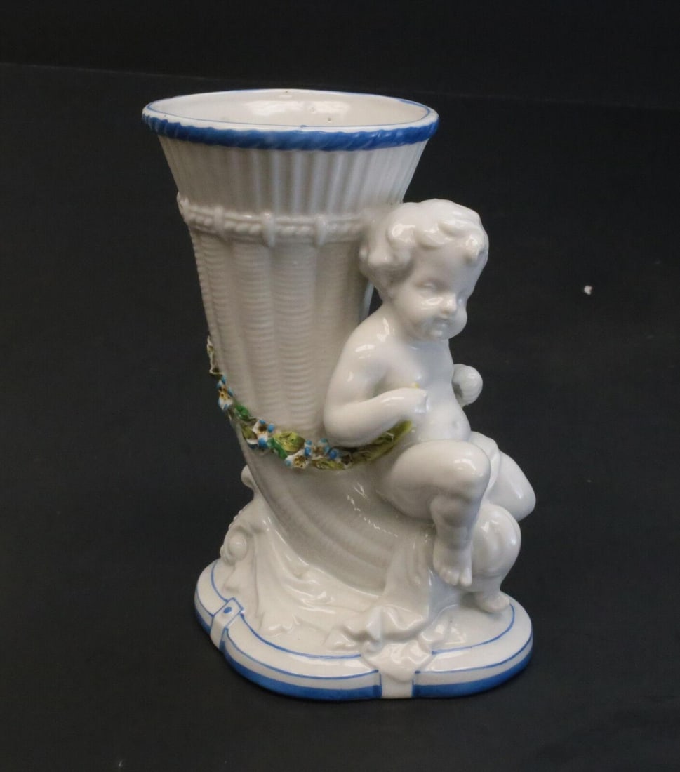Continental Hand Painted Porcelain Cherub Vase, Hand Painted Flowers and Vines: Continental hand painted porcelain cherub vase. A charming figural cherub with hand painted leaves and vines throughout a wicker horn to behind the cherub. Indistinguishable mark to the underside base