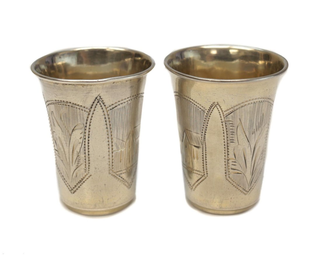 Pair of Russian 84 Silver Miniature Cups, Engraved Floral. Gold Wash Interior: Pair of Russian silver cups. Engraved houses and florals throughout the exterior of the cups. Light gold wash interior. Hallmarks to the underside base. Weight: Approx. 1.02 ozt Measurements: Approx. 