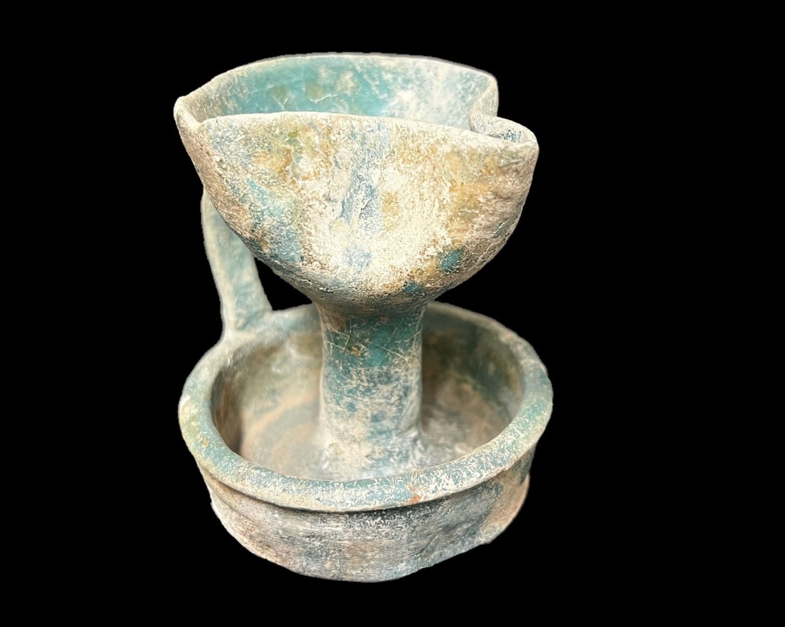 Islamic glazed pottery oil lamp: Islamic glazed pottery oil lamp, 10th century CE with iridescent turquoise blue glaze. Measurements: Approx. 3.75 inches height x 3.5 x 3.25 inches Condition: Condition commensurate with age, chips an