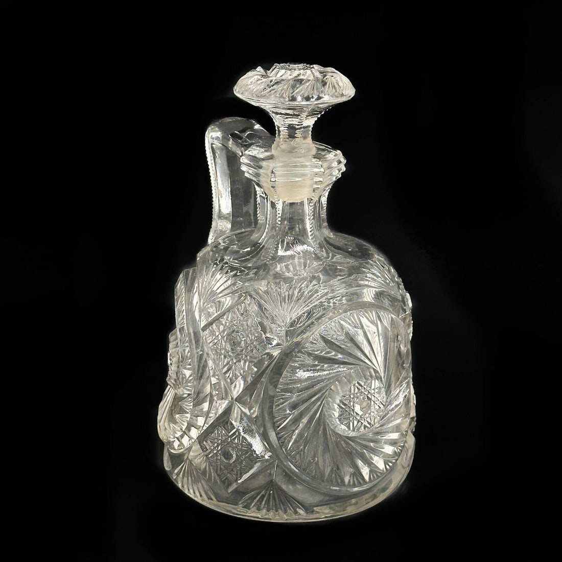 Vintage American Prescut Glass Decanter Jug Hobstar: Vintage American Prescut Glass Decanter Jug. Hobstar decoration, marked Pres Cut. Weight: Approx. 3 lbs Measurements: Approx. 5 inches diameter x 8.5 inches tall Condition: nicks to sides, impact to u