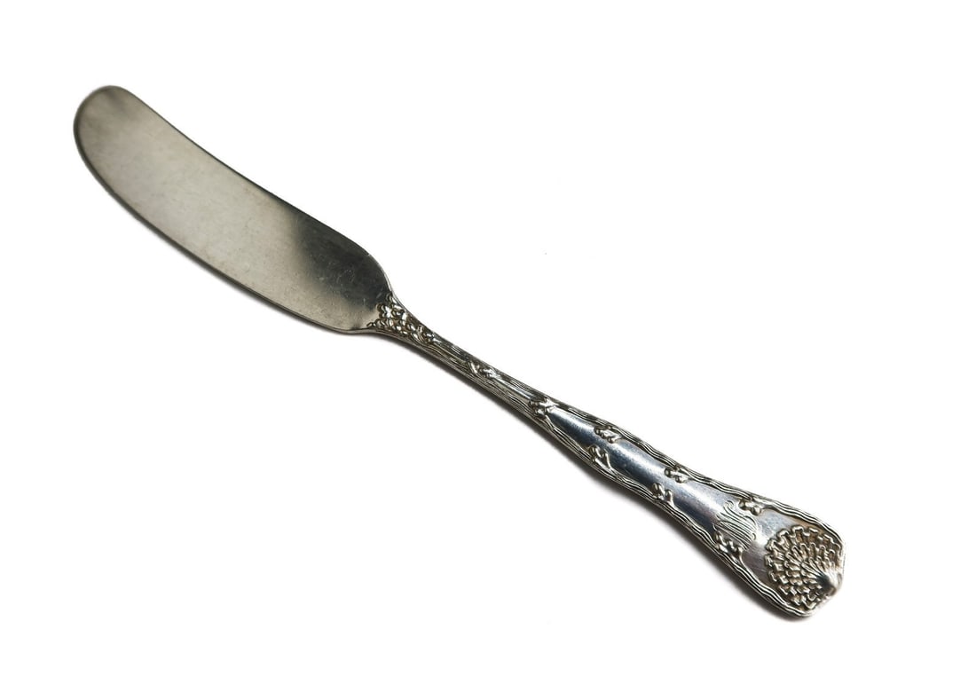Tiffany & Co. Sterling Silver Butter Pate Knife in Wave Edge Etched Shells: Tiffany & Co. sterling silver butter pate knife in Wave Edge. Etched leaves to handle. Two letter monogram to edge. Tiffany & Co. sterling silver marks to verso. Weight: Approx. 23.87 grams Measuremen
