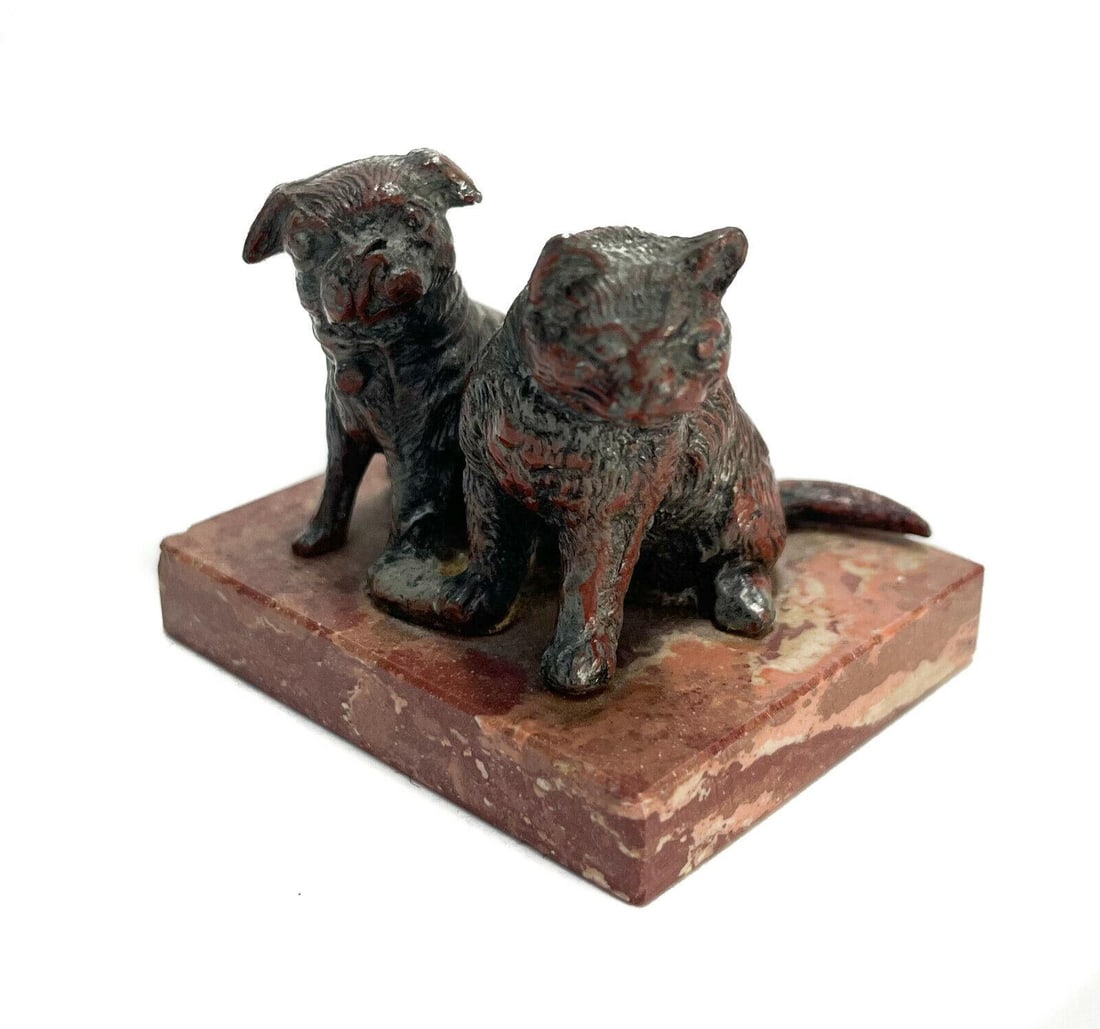 Patinated Metal Pug Dog and Cat Figurine on a Red Stone Base, circa 1930: Patinated metal pug dog and cat figurine, circa 1930. Mounted to a red stone base. Weight: Approx. 0.5 lbs Measurements: Approx. 2.5 inches x 2 inches x 2 inches tall Condition: Very good condition. A