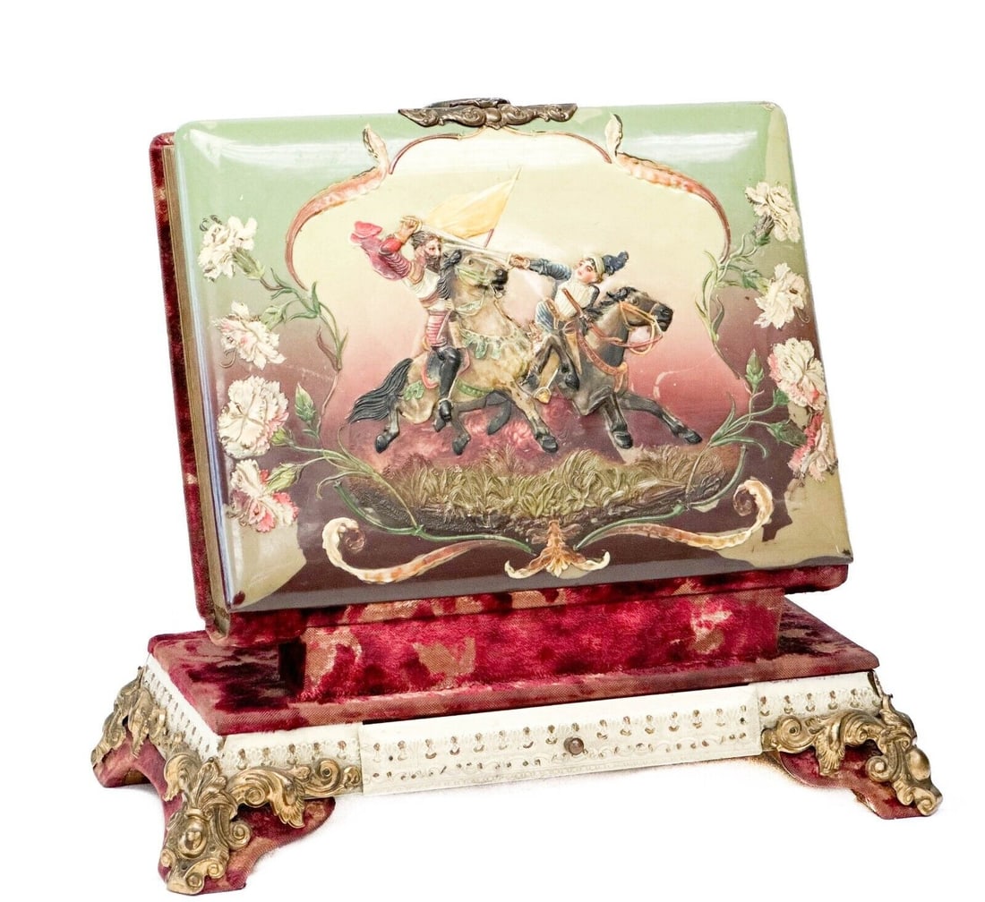 Standing Photo Album with Composition Warrior Scene, Velvet Stand c. 1920: Standing photo album with composition scene, circa 1920. Photo album with stand, front decorated with a relief composition warrior scene. Album opens from the top with a clasp to reveal 15 photo pages