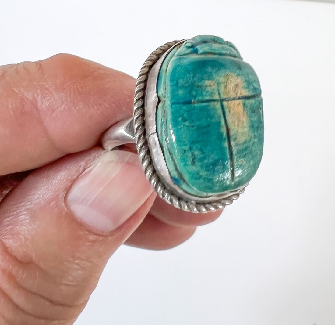 Sterling Silver Faience Scarab Ring Egyptian Revival c1920 size 7.75: Sterling Silver Faience Scarab Ring Egyptian Revival c1920, size 7.75. Scarab bead is bezel set with rope design trim. Marked 'Sterling' Measurements: Approx. 7.68grams; size 7.75; scarab 13 x 20mm Co