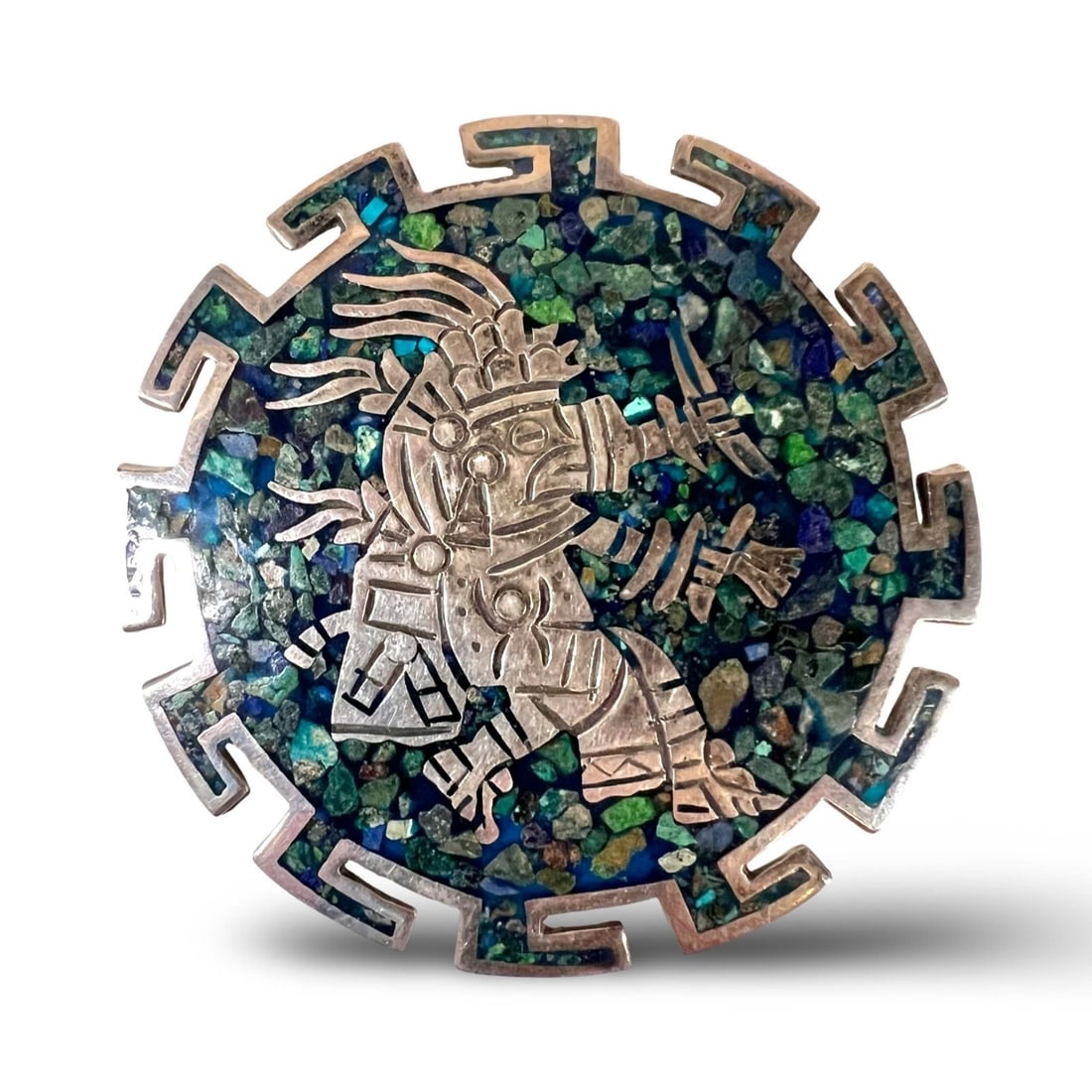 Vintage Taxco Mexico Pendant brooch Mayan Aztec warrior figure crushed stone: Vintage Taxco Mexico Pendant brooch sterling silver Mayan or Aztec warrior figure surrounded by inlaid mosaic crushed stone, likely including turquoise, lapis lazuli, and malachite. Marked sterling, T