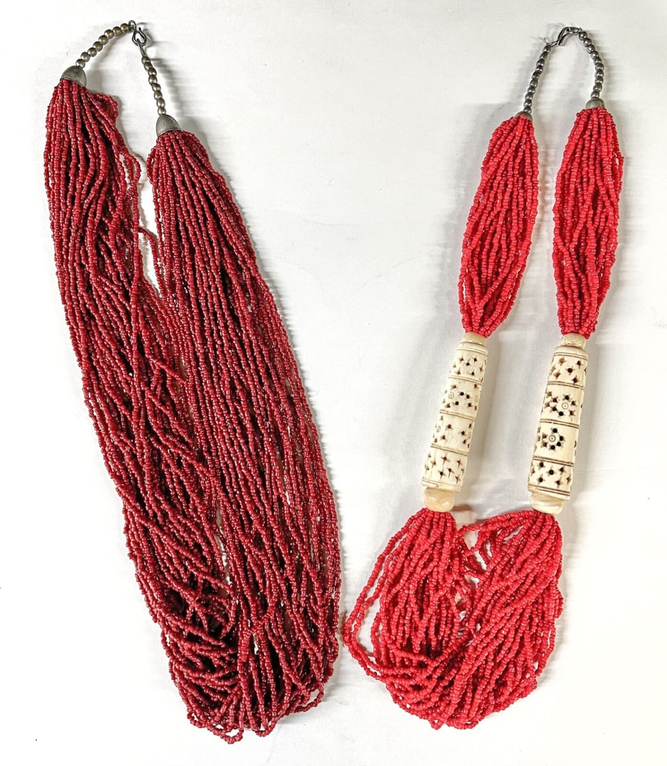 2pc Vintage Tribal multistrand Red Glass Seed Bead and Carved Necklaces: a Vintage Tribal Red Glass multistrand Seed Bead and Carved Bone Necklace. Large reticulated bone beads with 21 strand seed beads, metal hook closure; And, a vintage Tribal Deep Red Glass multistrand 