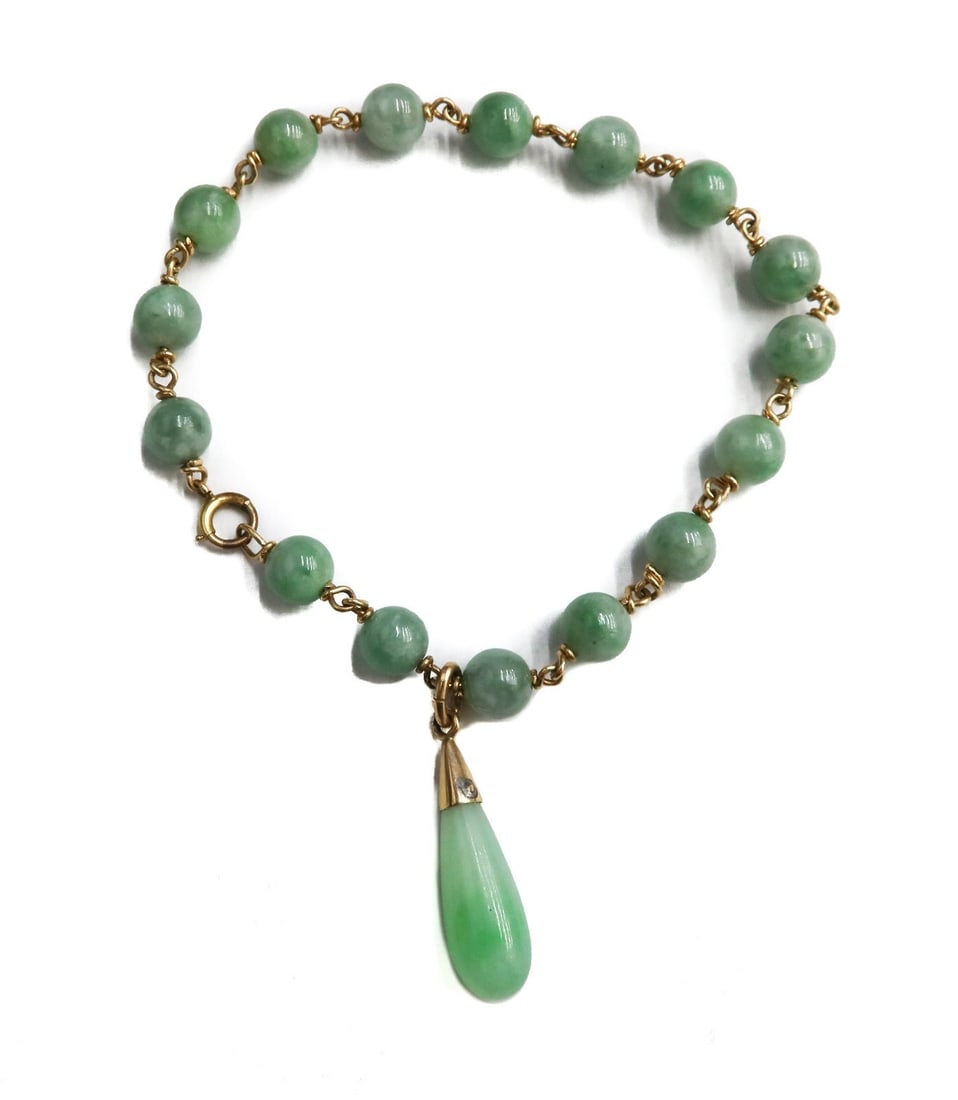 14k Yellow Gold and Jade Beaded Bracelet: 14k yellow gold and jade beaded bracelet. Jade beads measuring approximately 6.69mm with a teardrop charm measuring 17.55mm x 7.5mm. Marked 14k to clasp. Weight: Approx. 13.06 grams Measurements: Appr