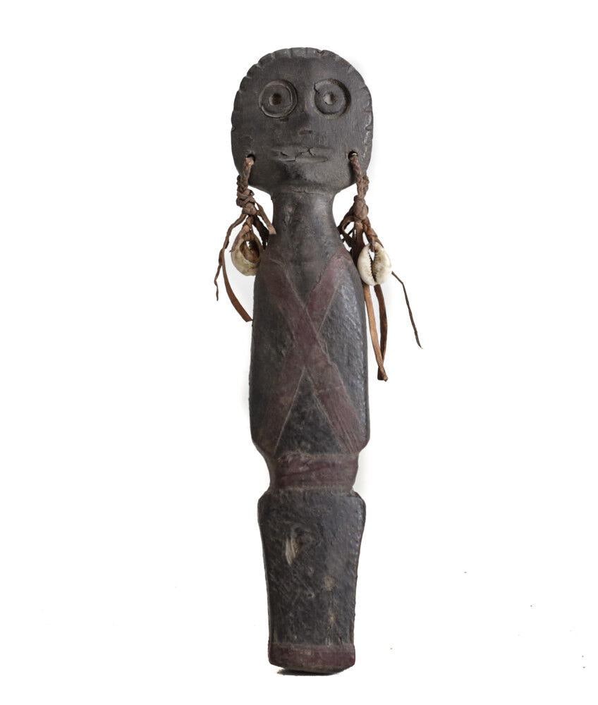 African Carved Wood Figural Doll with leather plaited ear ornaments with cowrie: African Carved Wood Figural Doll, with leather plaited ear ornaments with cowrie shell. Painted clothing. 0.25lb Measurements: Approx. 9.75" length. Condition: Condition commensurate with age, use. Si
