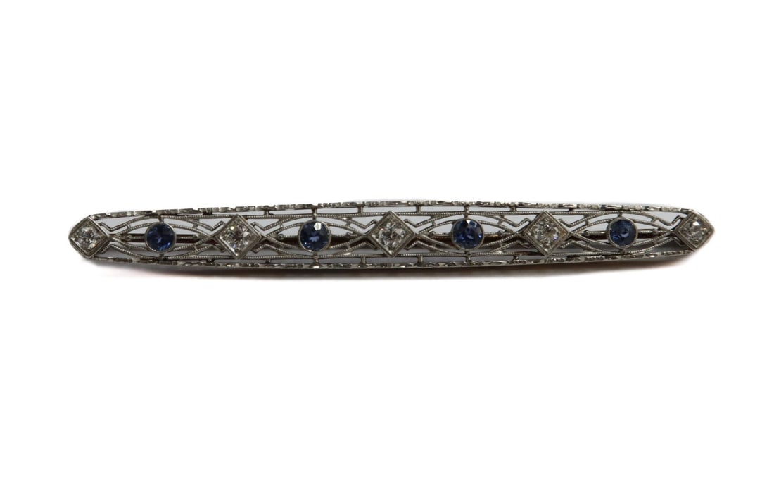 Victorian 14k Yellow and White Gold Diamond and Sapphire Brooch: Victorian 14k yellow and white gold diamond and sapphire brooch. 5 diamonds with 4 blue sapphires to brooch weighing 0.75 to the diamonds. Marked 14k to clasp. Weight: Approx. 6.77 grams