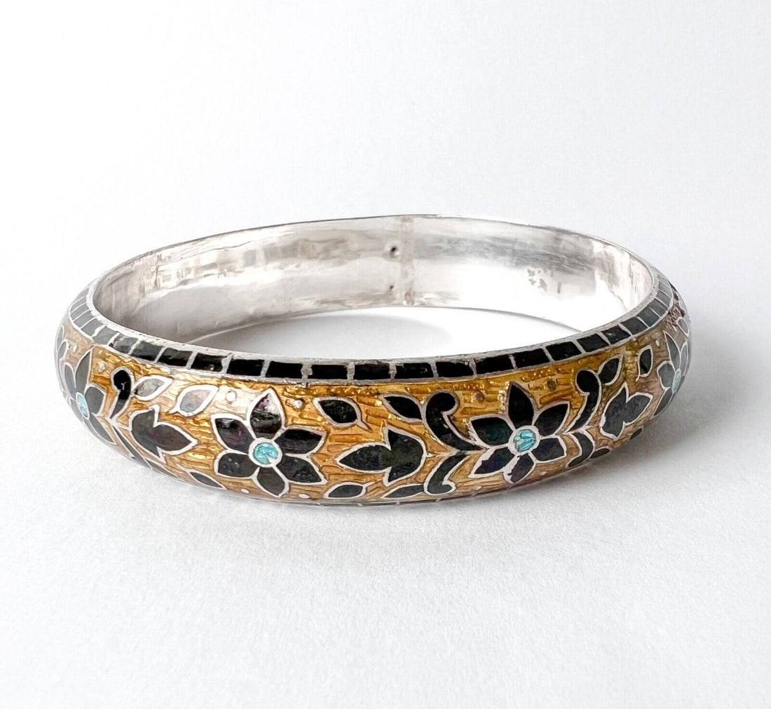 Vintage Enamel flowers on sterling silver bangle bracelet: Enamel flowers on sterling silver bangle bracelet, marked 925. In colors of black, turquoise and yellow. Measurements: Approx. 1.157ozt; interior diameter 2.3125 in.(20.8cm circumference); width 0.281