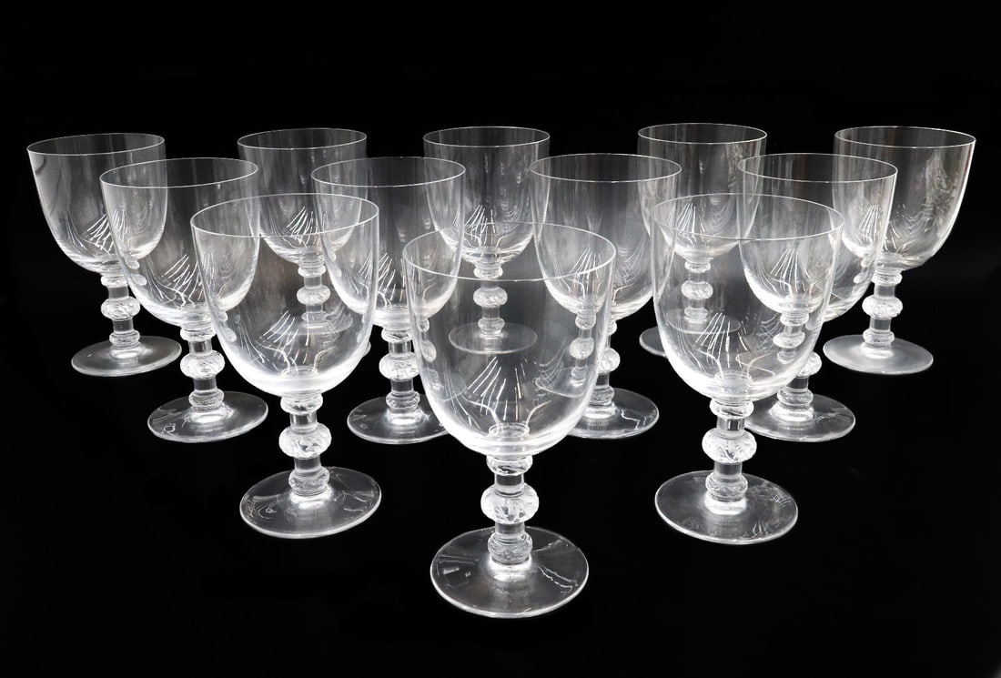 12 Lalique France Glass Tall Water Goblets in Saint Hubert Signed: 12 Lalique France glass tall water goblets in St. Hubert. Plain bowl with frosted etched foliate leaves to baluster stem. Underside etched Lalique France. Weight: Approx. 6 lbs Measurements: Approx. 3