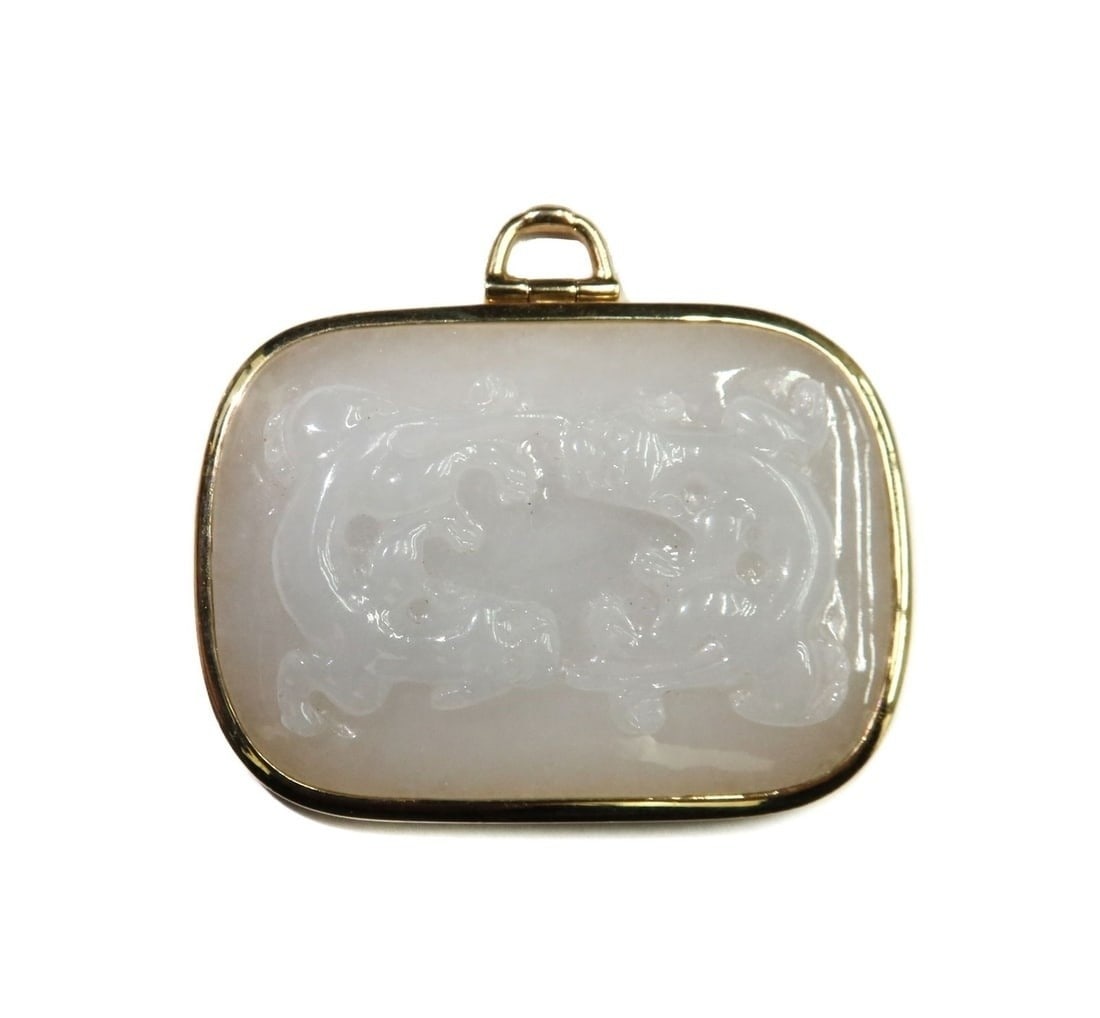 Gump's 14k Yellow Gold and White Jade Pendant Dragons: Gump's 14k Yellow Gold and White Jade Pendant Dragons. Two etched white dragons to the front. Marked Gump's 14k to back of frame. Weight: Approx. 25.45 grams Measurements: Approx. 1.75 inches x 1.5 in