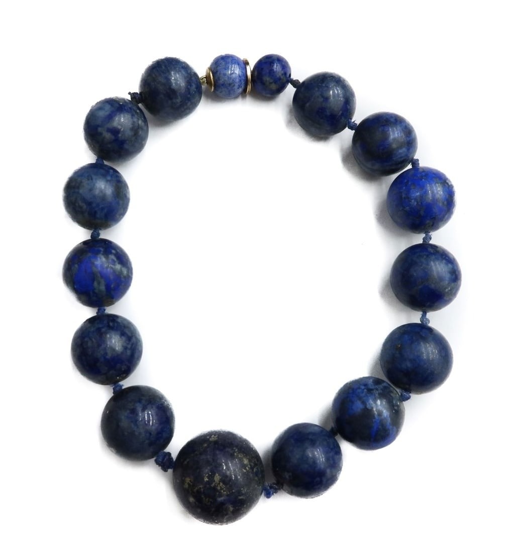 14k Yellow Gold and Lapis Lazuli Single Strand Beaded Necklace: 14k Yellow Gold and Lapis Lazuli Single Strand Beaded Necklace. The lapis beads measuring from 13.63mm to 24.62mm. Length of necklace suggests choker style. The clasp tests for 14k gold. Weight: Appro
