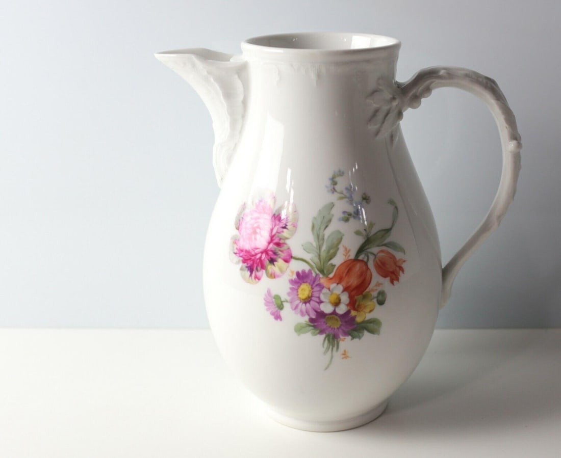 Weimar KPM Porcelain Milk Pitcher hand painted black cross 1914-19: Weimar KPM Porcelain Milk Pitcher, hand painted florals, butterfly, molded handle in the form of a branch. Makers mark on bottom with Black Cross, c1914-1919. Measurements: Approx. 8.375 inches height