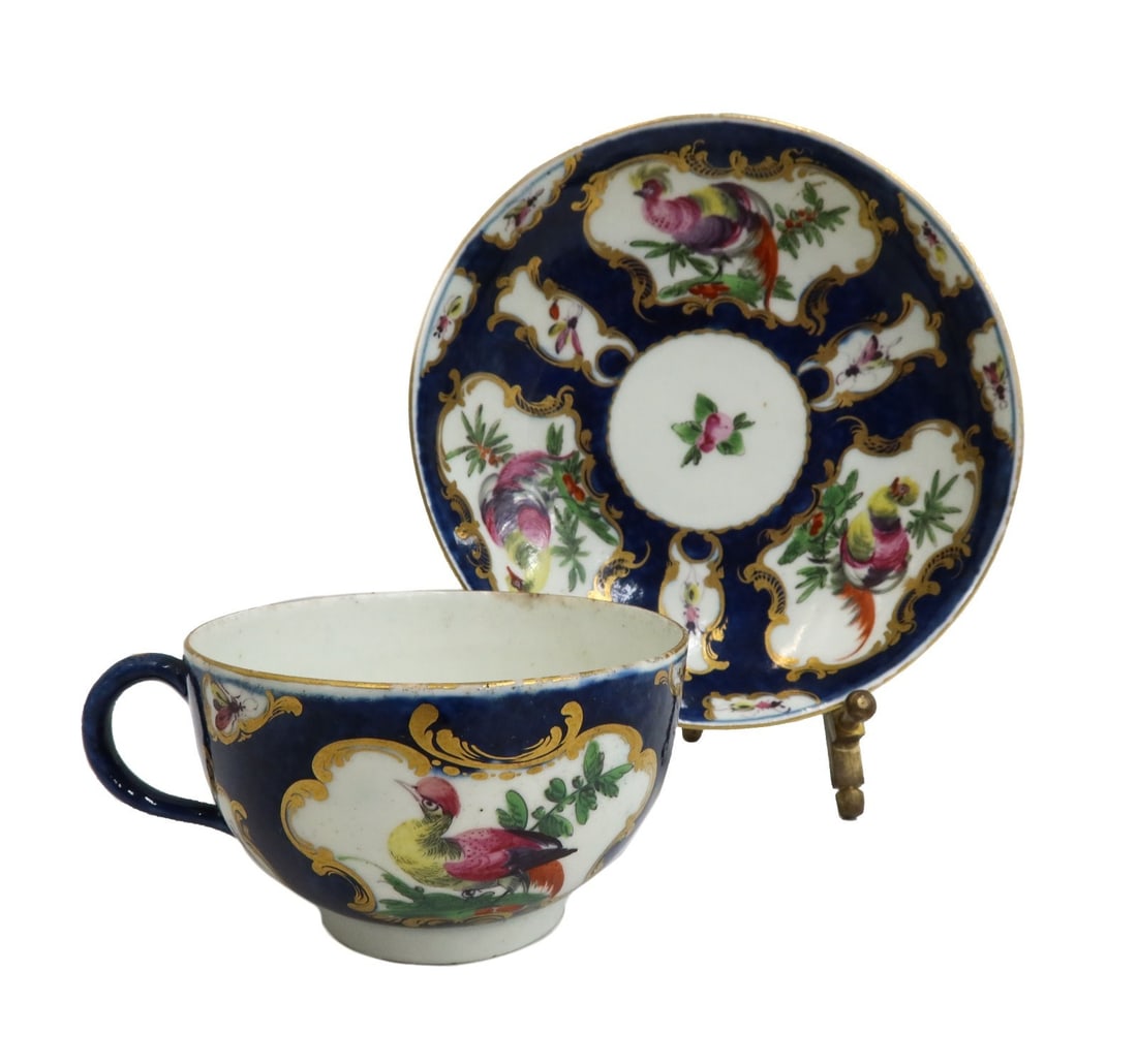 Royal Worcester England Porcelain Cup and Saucer Exotic Birds 18th Century: Royal Worcester England porcelain cup and saucer exotic birds, 18th Century. Blue scale with gilt accents and hand painted exotic birds throughout. Royal Worcester blue W mark to underside. Weight: Ap