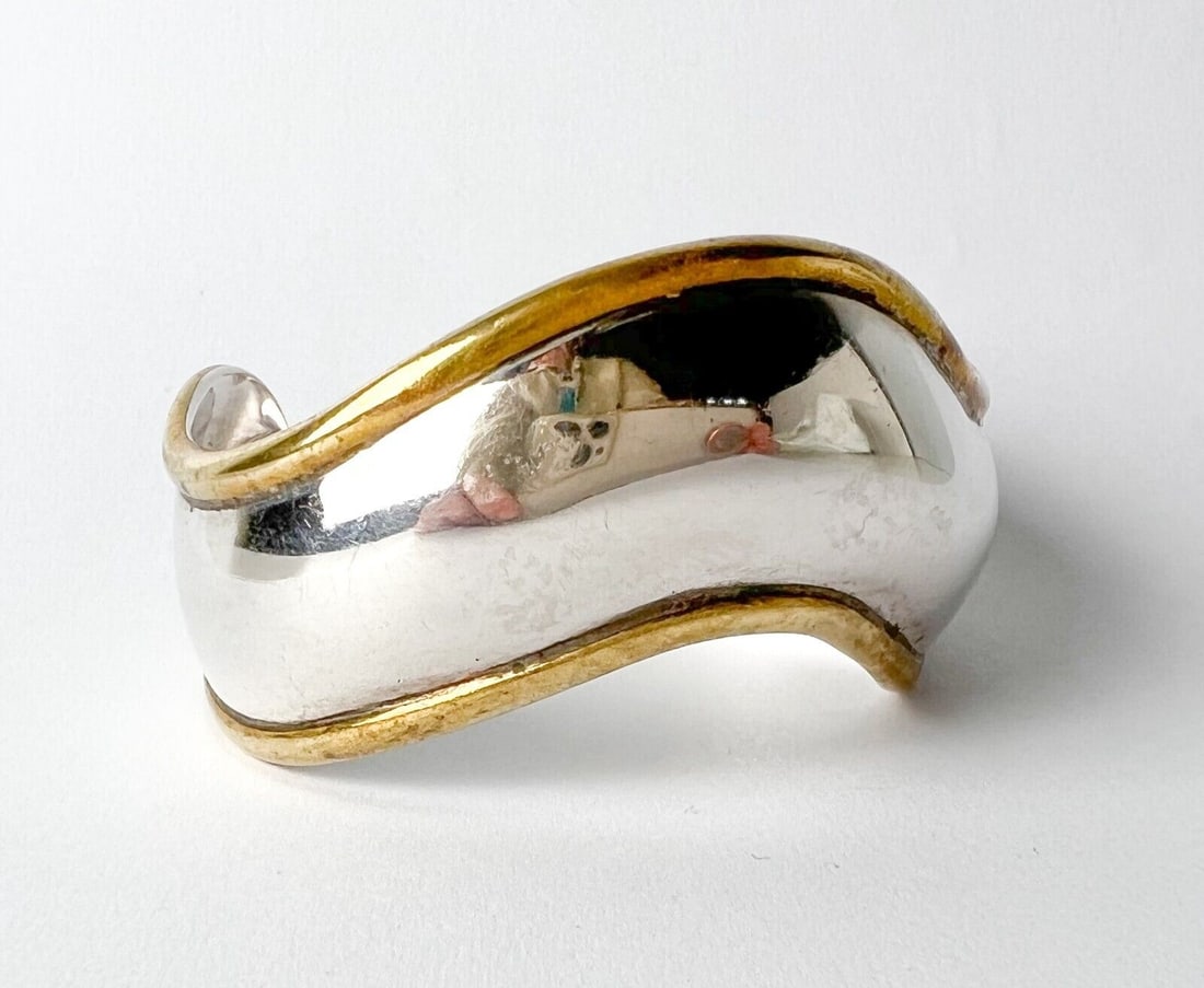 Vintage Mexican Taxco Sterling and Brass Cuff Bangle Bracelet: Mexican Sterling and Brass Cuff Bangle Bracelet, wavy design. Marked 'TS-102 Mexico 925' Measurements: Approx. 0.843ozt; interior diameter 2.25 in. x 1.75 in.; width 1.0 in.; exterior diameter 2.5 in 