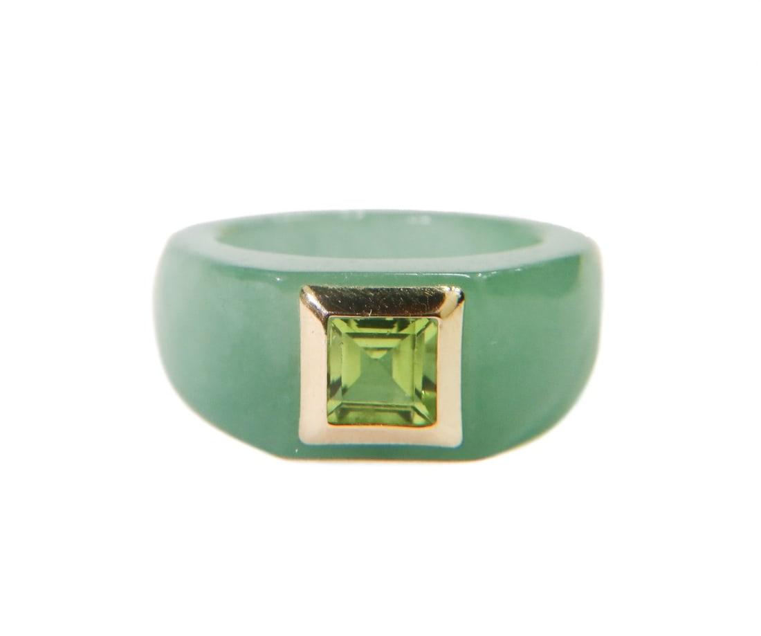 14k Yellow Gold Green Jade and Peridot Ring Size 8: 14k yellow gold green jade and peridot ring, size 8. Jade band with a square cut peridot jewel to center measuring around 5.32mm x 5.32mm. Gold frame around the peridot tests for around 14k gold. Weig