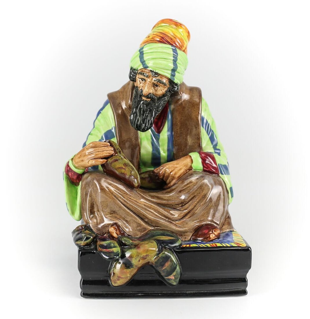 Royal Doulton Porcelain Figurine, 'Cobbler' HN1706 Hand Painted Seated Man: Royal Doulton Porcelian Figurine 'Cobbler' HN1706. Charmingly Hand Painted Male figure seated mending shoes wearing a striped turban and long beard. Marked Royal Doulton. Weight 1.5 pounds. Measuremen