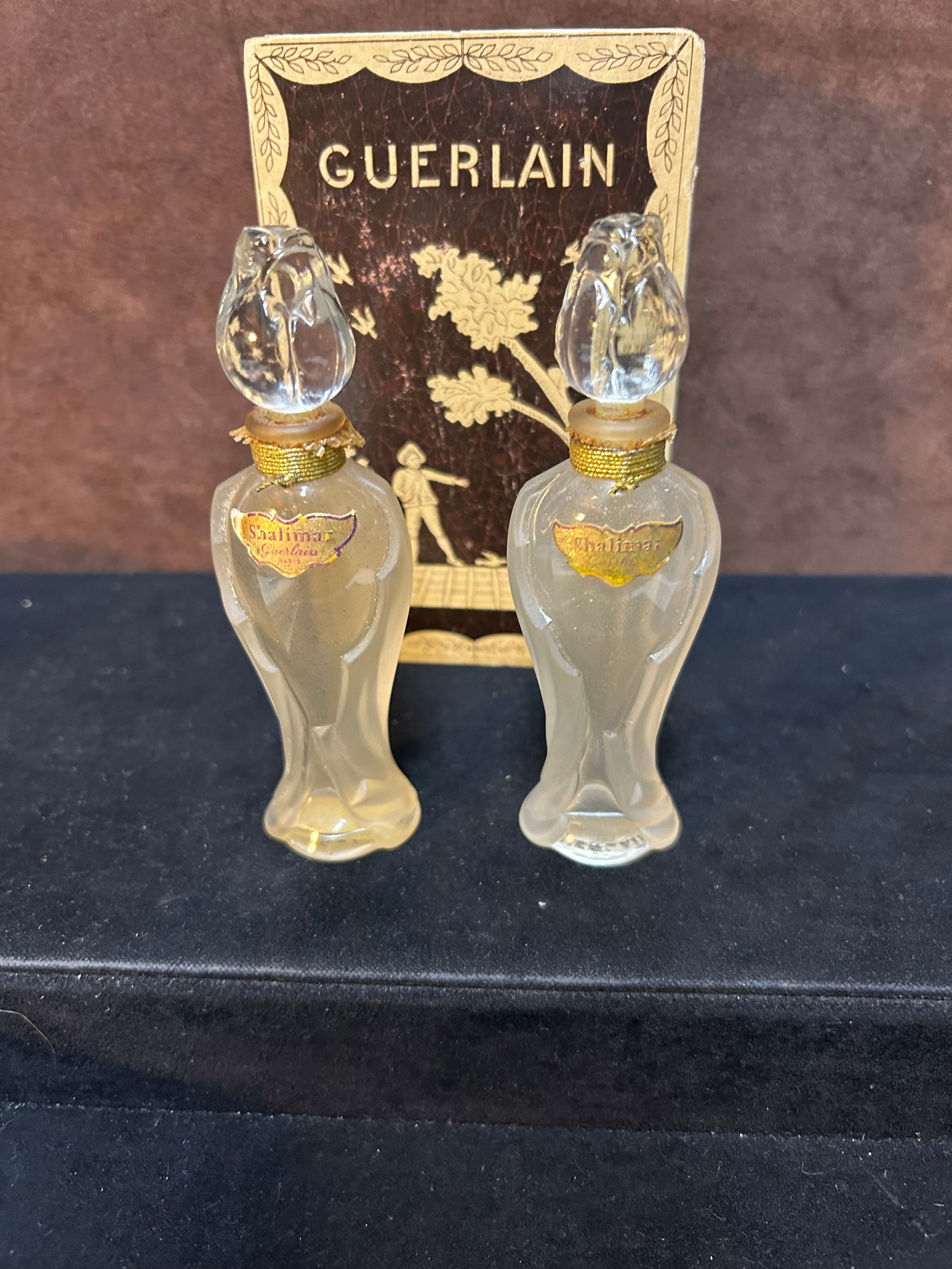 Vintage Set of Two Guerlain Shalimar “Rosebud” Flacon Amphora Perfume Bottles – 1950s,: This listing is for a set of two vintage Guerlain Shalimar perfume bottles, each measuring approximately 4 3/4 inches tall. These elegant “Flacon Amphora” bottles feature the iconic rosebud st