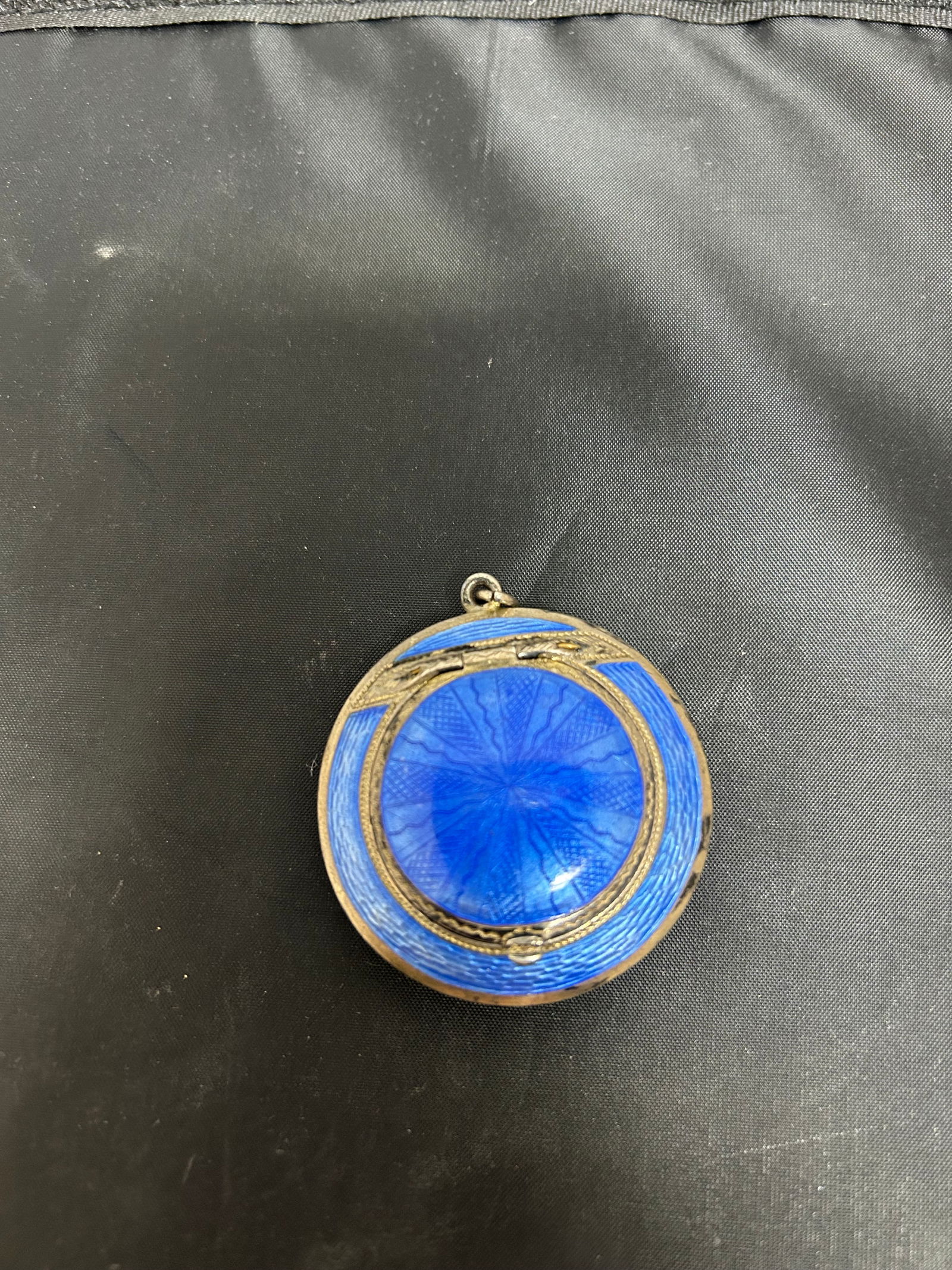 Sterling Silver Blue Guilloché Enamel Pendant Locket Compact, c.1915–1930: This petite round case wears a suspension loop like a jewel, so it can be slipped on a ribbon or chain and carried at the throat as a choker or tucked into a small evening bag. Inside, a gilt interior