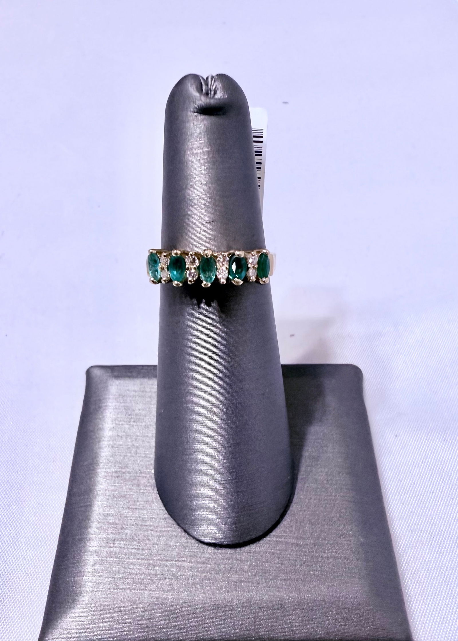 14K Yellow Gold Emerald and Diamonds in Harmony Band Ring – Size 5.5: A graceful design that balances vivid color with timeless brilliance, this 14K yellow gold Emerald Harmony band features five oval-cut emeralds alternating with eight sparkling round diamonds totaling