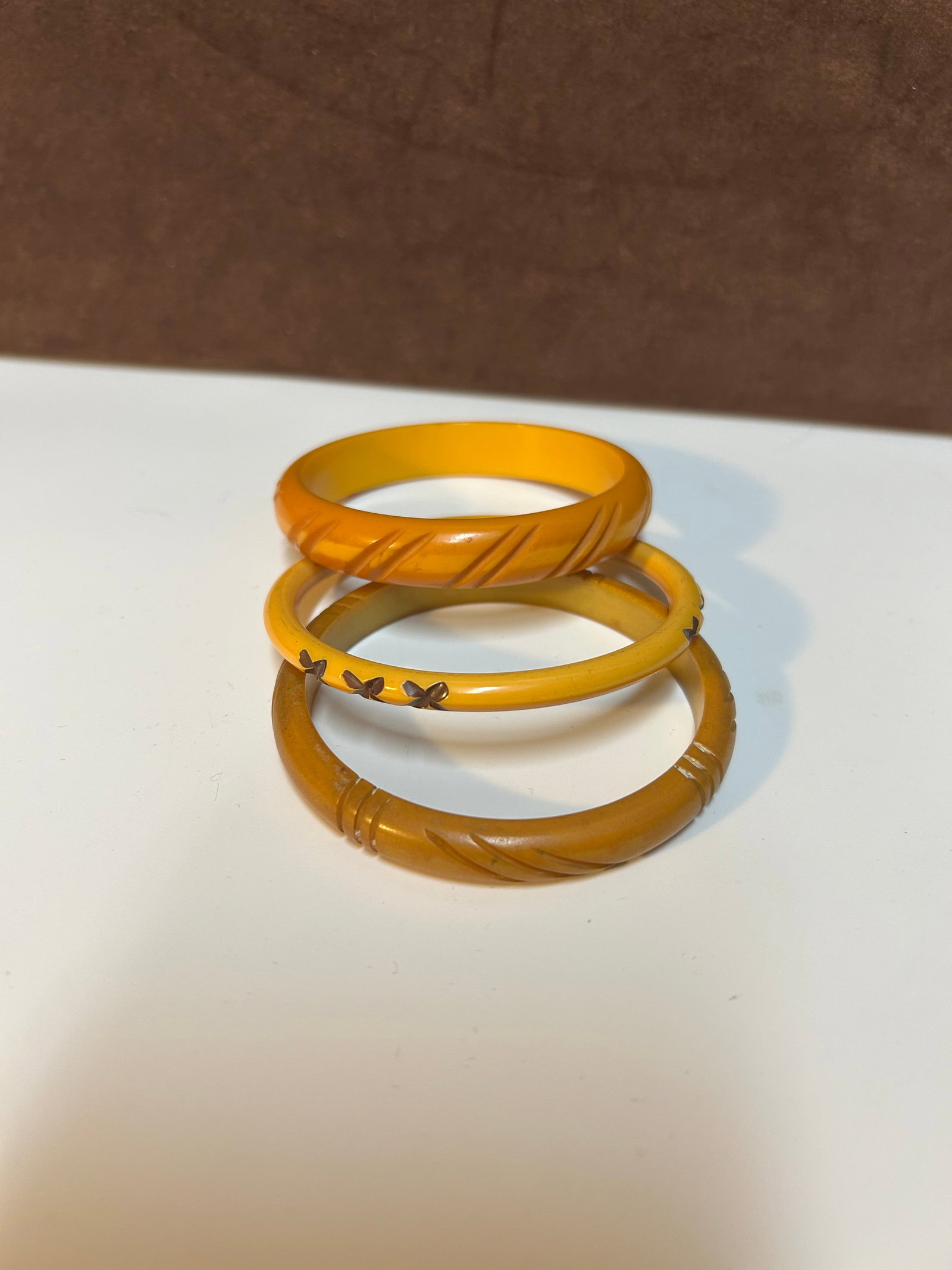 Set of Three Art Deco Butterscotch Bakelite Carved Bangle Bracelets Circa 1930-1950: This set of three butterscotch Bakelite bangle bracelets dates from approximately 1930 to 1950, spanning the Art Deco to early mid-century period when Bakelite reached the height of its popularity. Ea