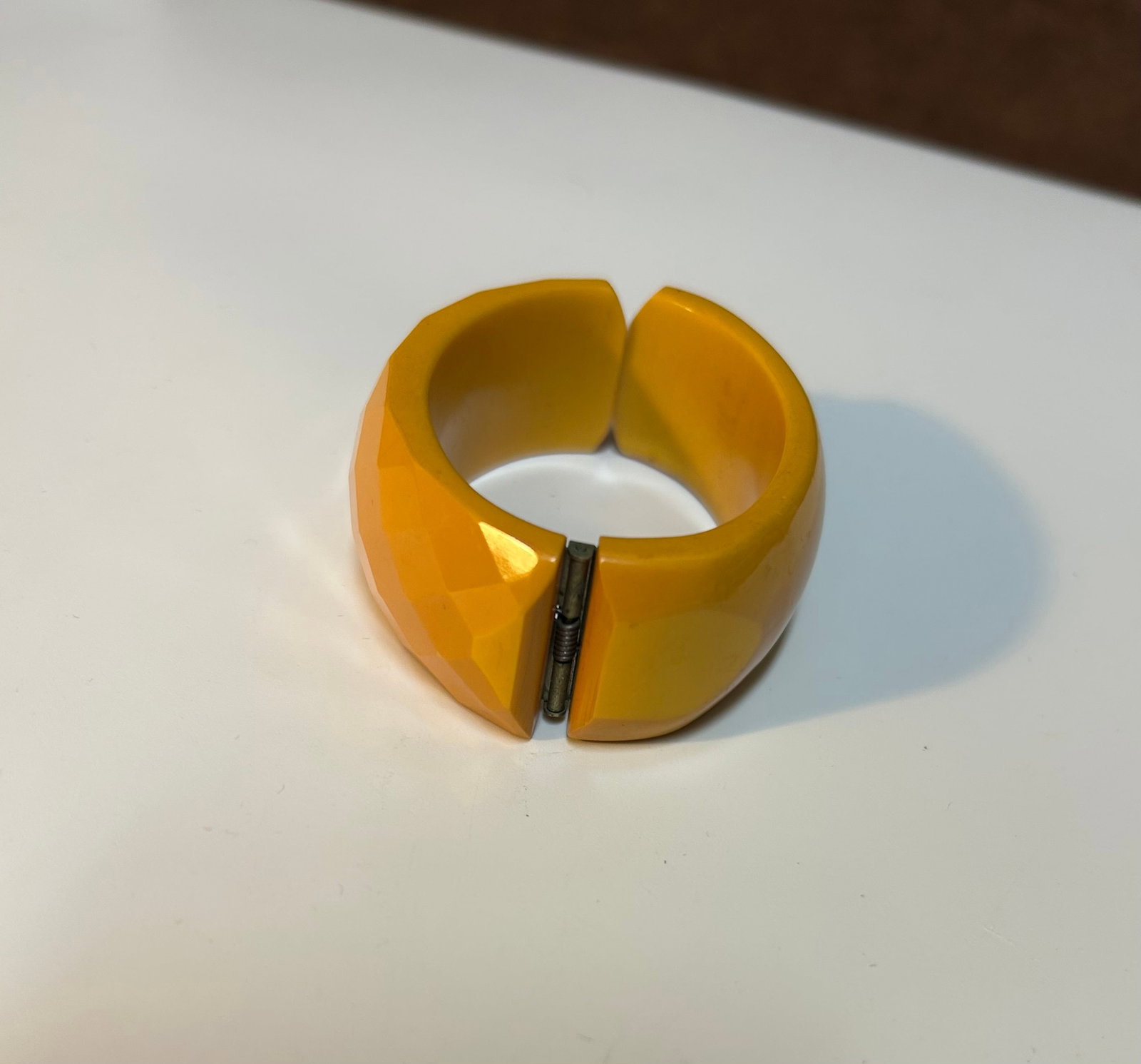 Butterscotch Bakelite Faceted Hinged Bangle Bracelet Circa 1930s: This elegant butterscotch Bakelite bangle bracelet dates from the 1930s, during the height of the Art Deco era when Bakelite jewelry flourished in popularity. Crafted from authentic phenolic Bakelite,