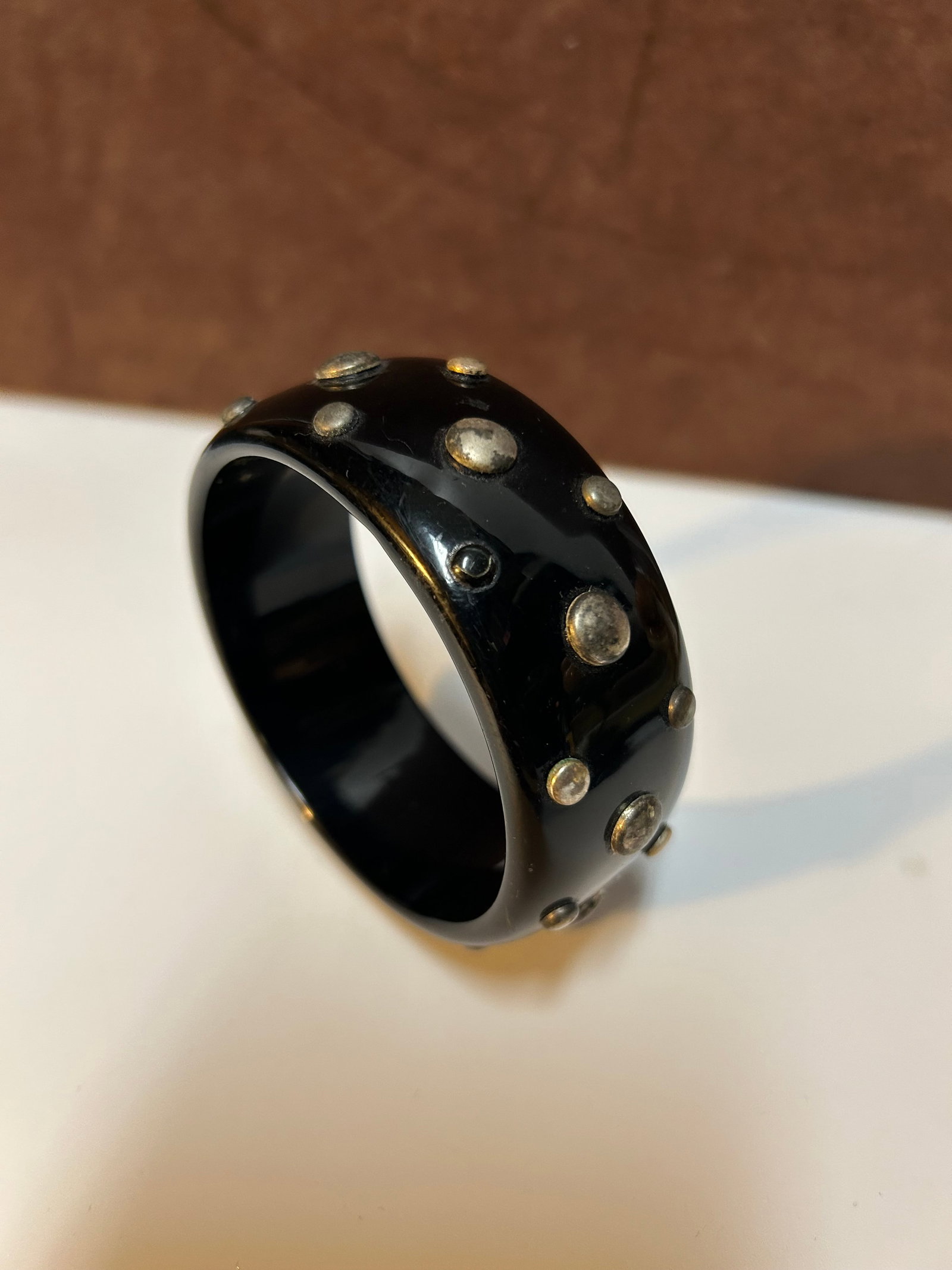 Art Deco Black Bakelite Studded Bangle Bracelet with Brass Accents Circa 1930s-1940S: This bold black Bakelite bangle bracelet dates to the Art Deco period of the 1930s–1940s, when Bakelite was widely used in jewelry and decorative design. Crafted from authentic phenolic Bakelite, th