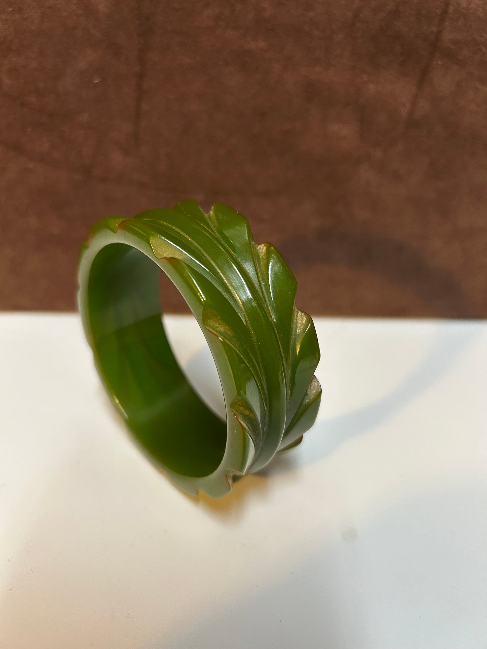 Carved Green Bakelite Bangle Bracelet with Leaf Design Circa 1940s: This carved green Bakelite bangle bracelet dates from the 1940s, during the Art Deco period when Bakelite jewelry rose in popularity due to wartime metal shortages. The bracelet features an exquisite 
