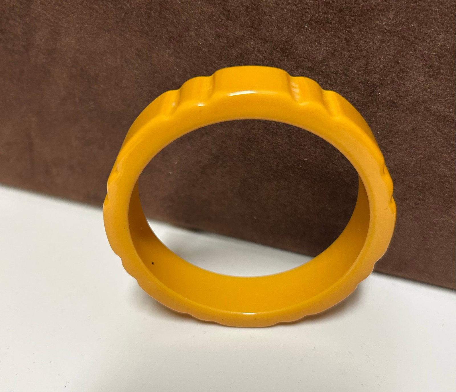 Vintage Bakelite Bangle Bracelet – Yellow Scalloped Carved Design: This vintage Bakelite bangle bracelet features a cheerful yellow tone and a beautifully carved scalloped edge design. Crafted during the mid-20th century, Bakelite jewelry became iconic in the 1930s a