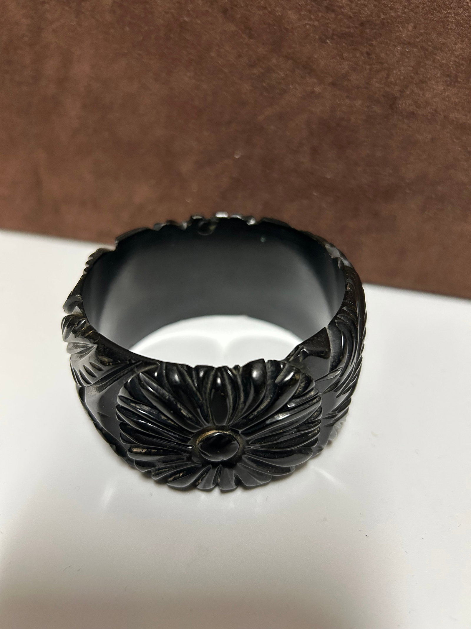 Carved Black Bakelite Bangle Bracelet With Floral Motif: This striking vintage Bakelite bangle features deeply carved floral and leaf motifs, creating bold texture and dimensional beauty. Crafted during the Bakelite jewelry era of the 1930s–1960s, this pi