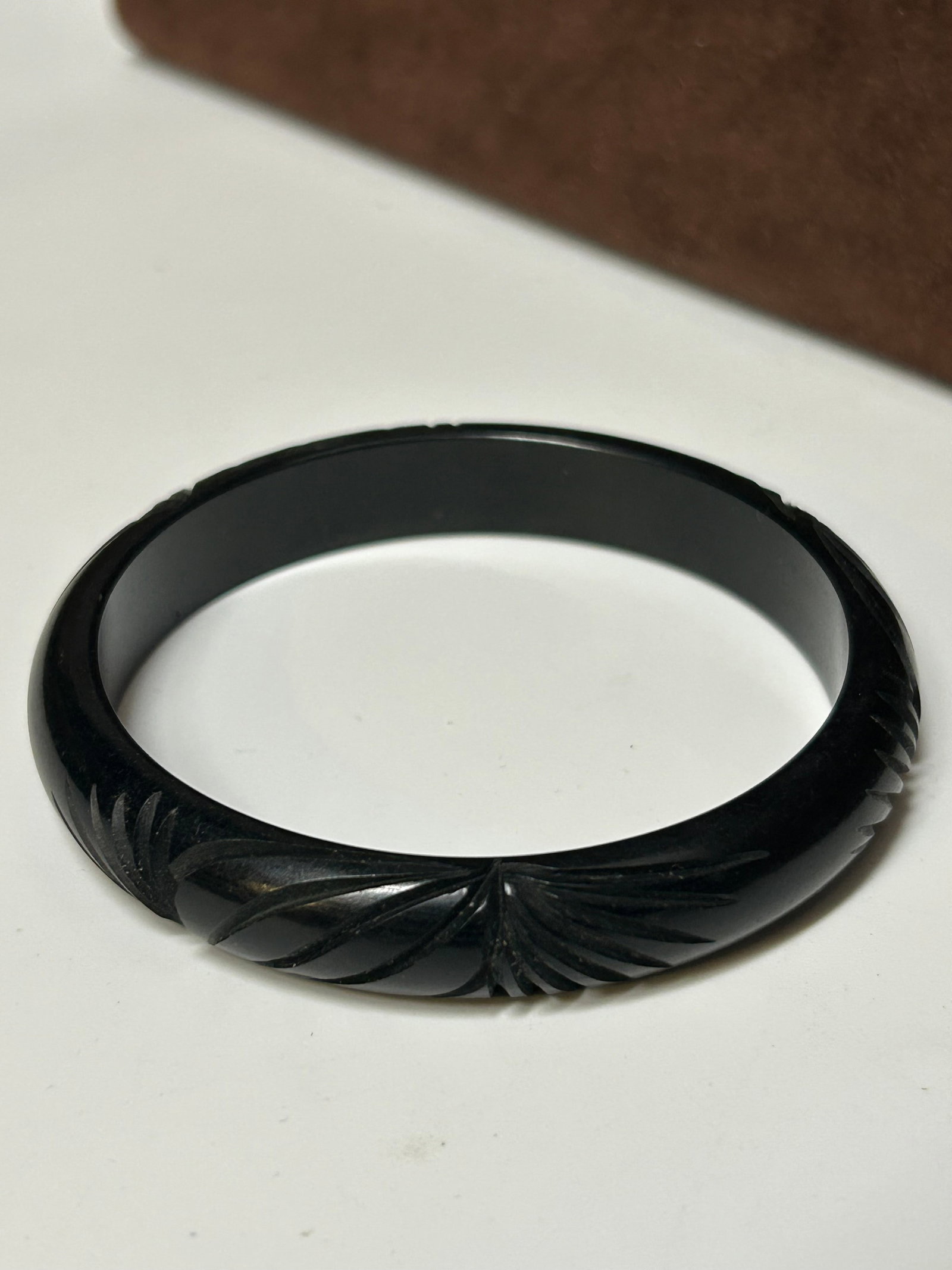 Vintage Carved Black Bakelite Bangle Bracelet with Geometric Design: This vintage carved Bakelite bangle features a deep jet-black tone with a crisp geometric carved pattern, creating a striking and refined silhouette. The bold color and stylized carving reflect the st