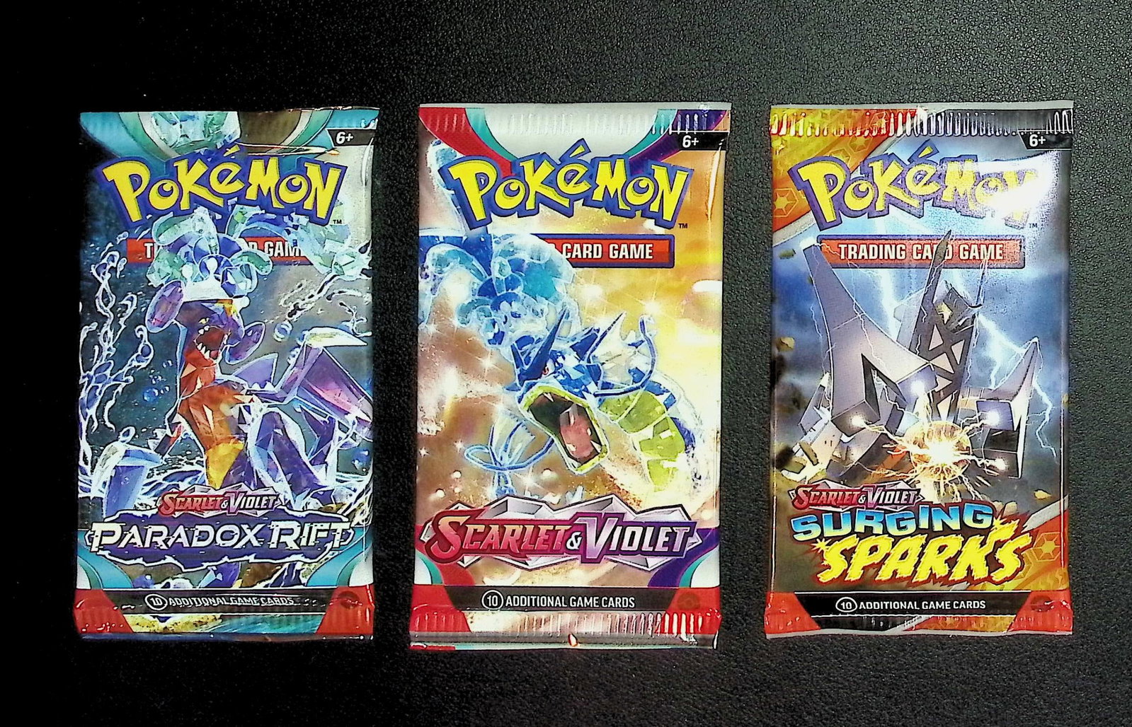 3 COUNT: 1 - Pokemon Paradox Rift, 1 - Scarlet & Violet, & 1 - Surging Sparks Booster Packs: Pokemon Trading Card Game Cards, Charizard, Pikachu, Mewto, EX, Referse Holo, Holo Rare Cards, Secret Rare Cards, Full Art Cards, Evee, 3 Stars Ultra Rare Cards, Double Rare, Illustration Rare, Specia
