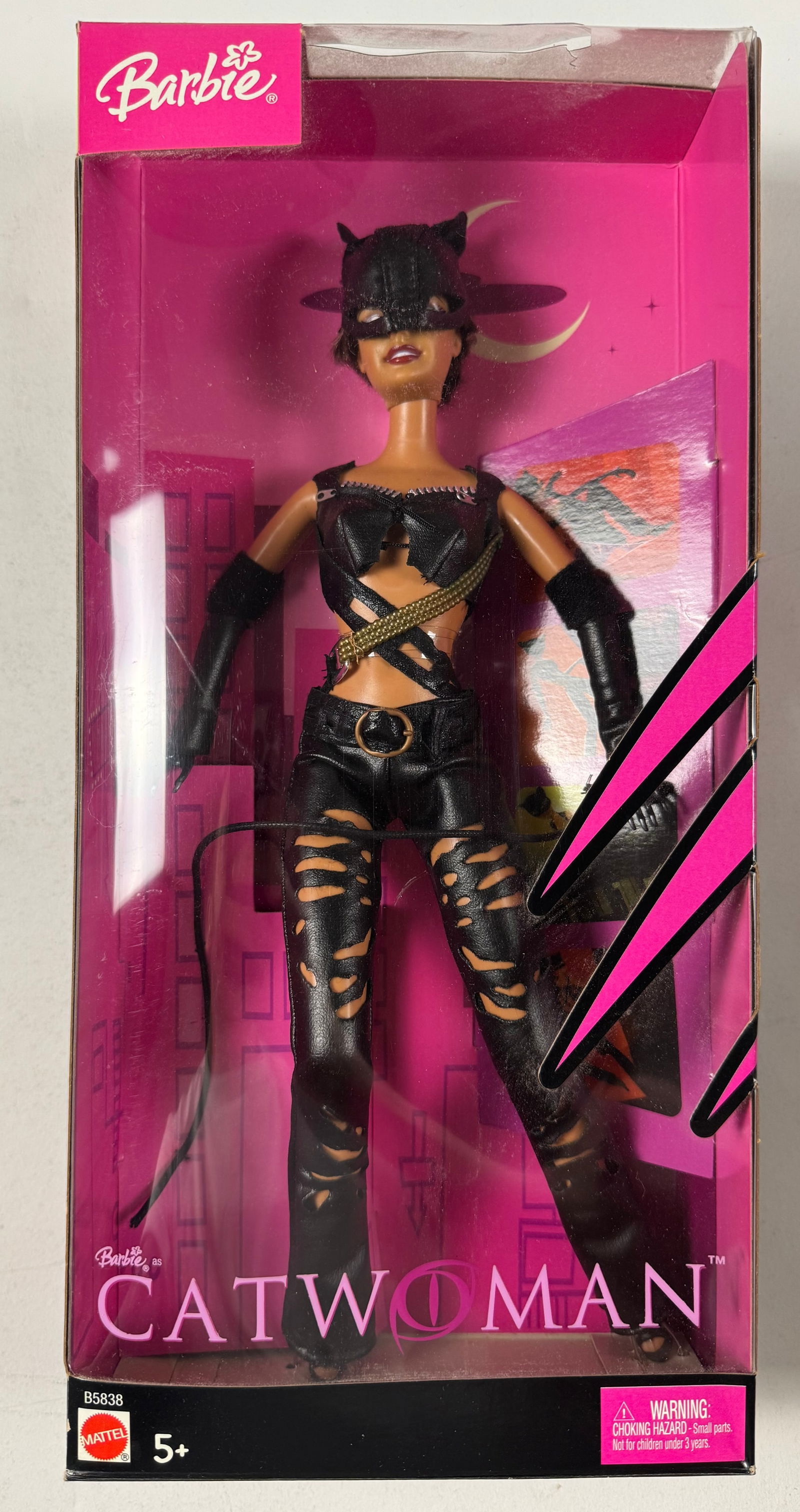 Barbie Catwoman Played by Halle Berry Mattel 2004 Patience Phillips: The outfit is designed to reflect the costume worn by Halle Berry in the movie, featuring black faux leather with textured stitching and sharp cutouts that reveal her midriff and legs. The asymmetrica