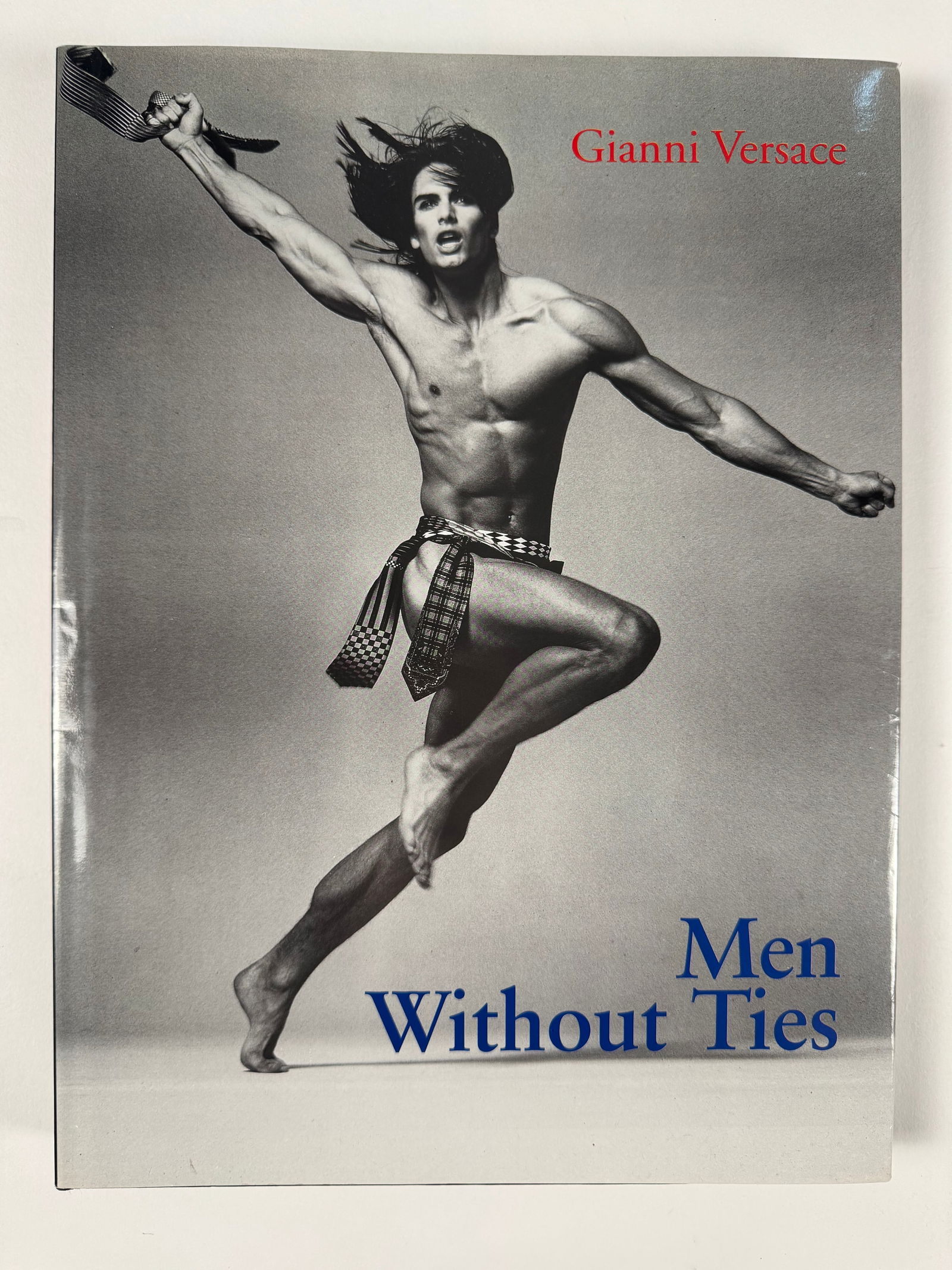 Men Without Ties by Gianni Versace Out of Print Hardcover Book: Top photographers Bruce Weber, Richard Avedon, and Herb Ritts interpret Gianni Versace's kaleidoscopic vision of men's fashion. Whether at ease by the sea, or dressed for business in New York or Milan