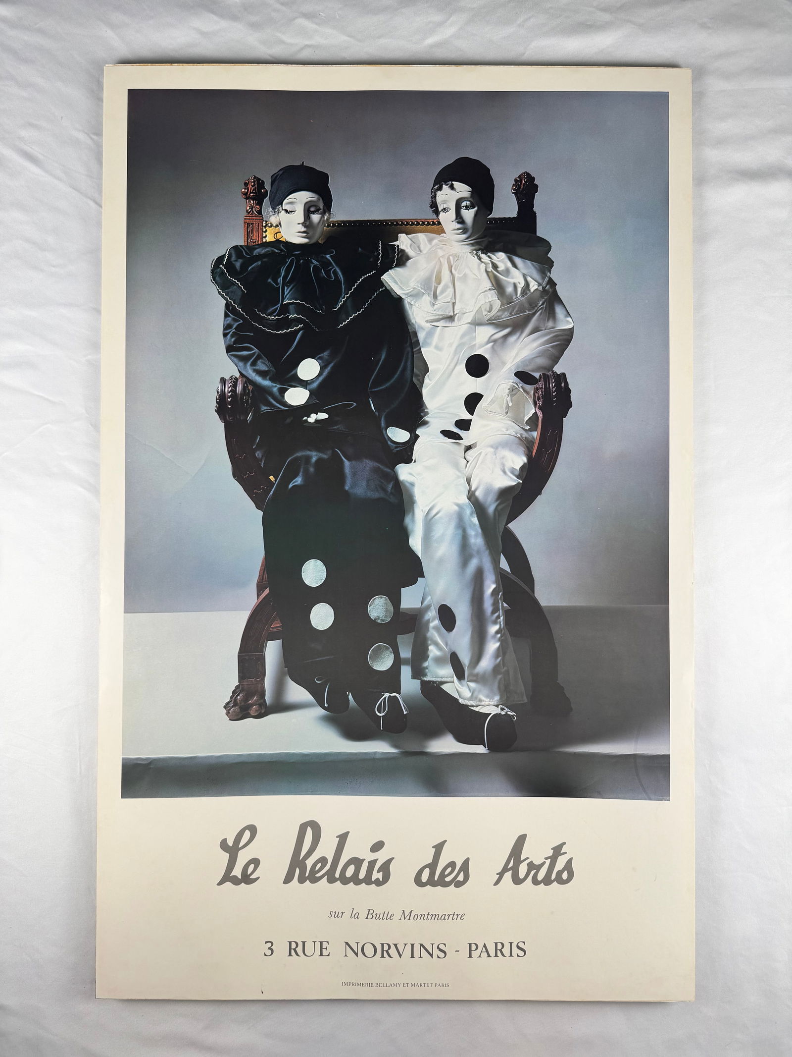 Le Relais des Arts Pierrot Café Poster, Paris: Printed poster advertising Le Relais des Arts located at 3 Rue Norvins in Montmartre, Paris. Depicts two Pierrot figures seated together. Imprimerie Bellamy et Martet, Paris.