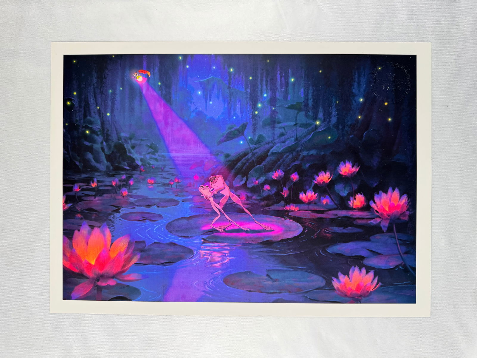 Disney The Princess and the Frog Tiana and Naveen Commemorative Lithograph: Art print depicting Tiana and Prince Naveen dancing on lily pads from Disney The Princess and the Frog. Studio seal embossed in the upper corner.