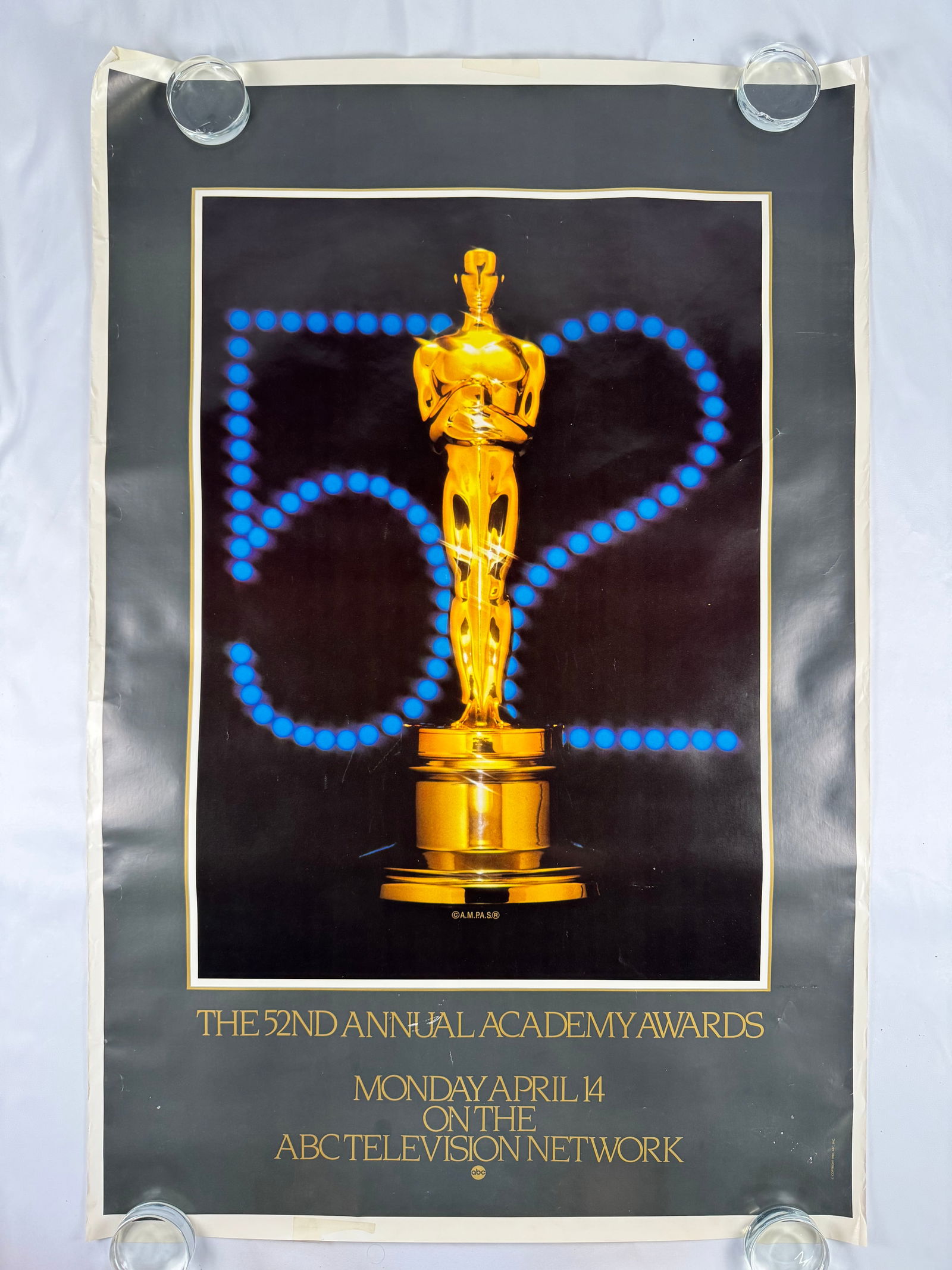 52nd Annual Academy Awards 1984–1985 Movies Film Poster: A vintage poster produced for the 52nd Academy Awards showcasing a classic golden Oscar statue against a dark backdrop; noticeable aging, wrinkles, and border wear reflect long-term storage.