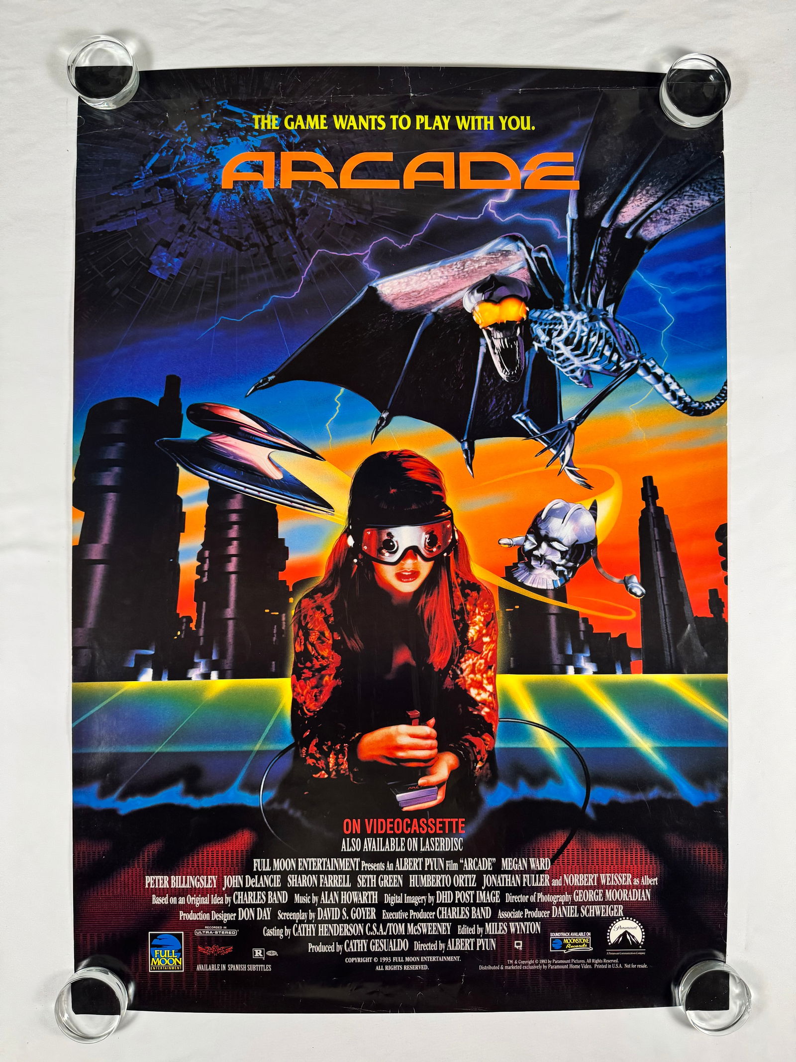 Arcade 1993 VHS Megan Ward Original Vintage Movie Poster: Arcade is a 1993 B-movie science fiction film directed by Albert Pyun, written by David S. Goyer and produced by Full Moon Entertainment. It stars Megan Ward, Peter Billingsley, John de Lancie, Sharon