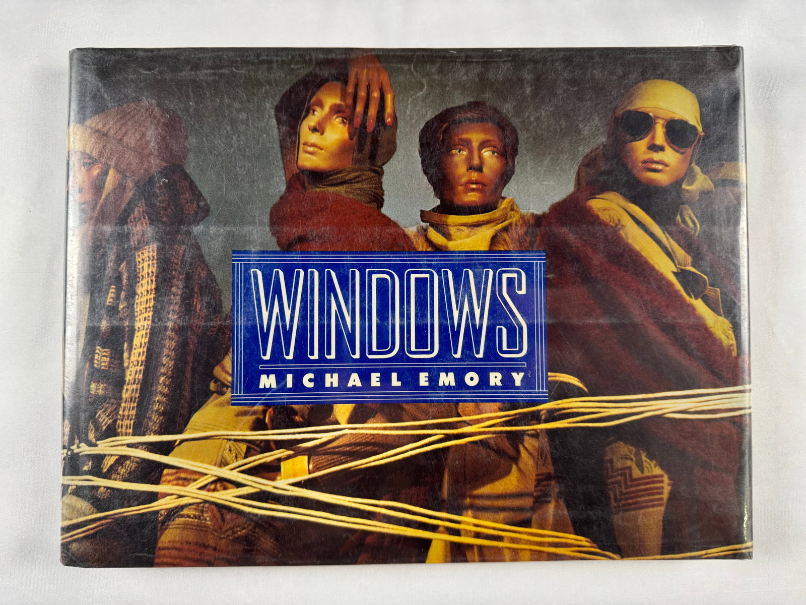 Michael Emory Windows 1977 First Edition Retail Display Design Book Hardcover: A collection of evocative fashion and street-inspired photography by Michael Emory, focusing on mannequins and window displays. The images blend realism and surrealism, creating a moody visual study o
