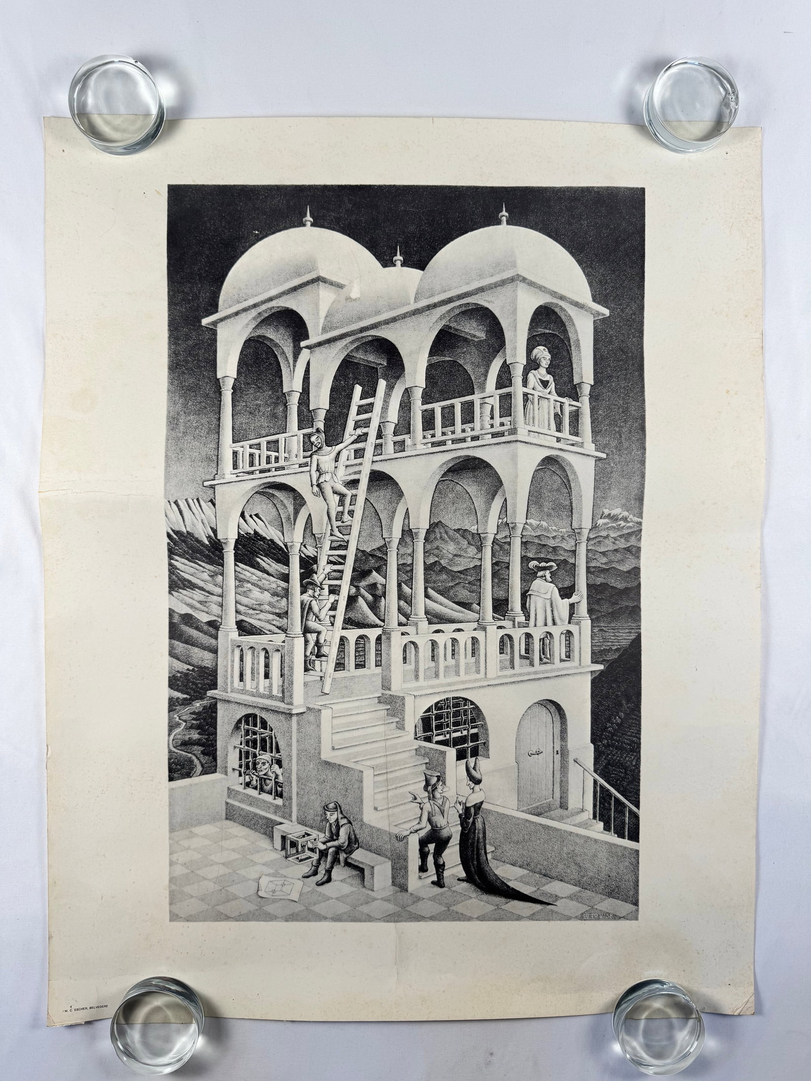 M.C. Escher Belvedere Poster Art Print: Maurits Cornelis Escher (17 June 1898 – 27 March 1972) was a Dutch graphic artist who made woodcuts, lithographs, and mezzotints, many of which were inspired by mathematics. Despite wide popular int