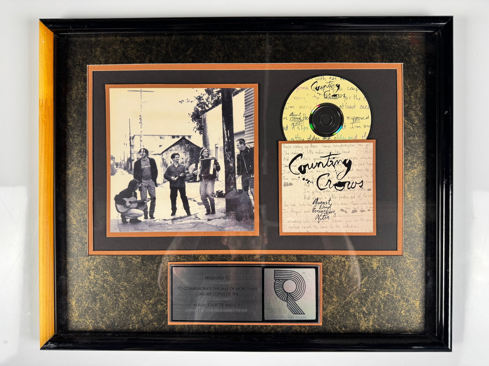 Counting Crows August and Everything After RIAA Platinum Record Sales Award Display: Official RIAA-certified sales award commemorating more than 1,000,000 copies sold of Counting Crows' debut album August and Everything After. The shadowbox display features a platinum record, band pho