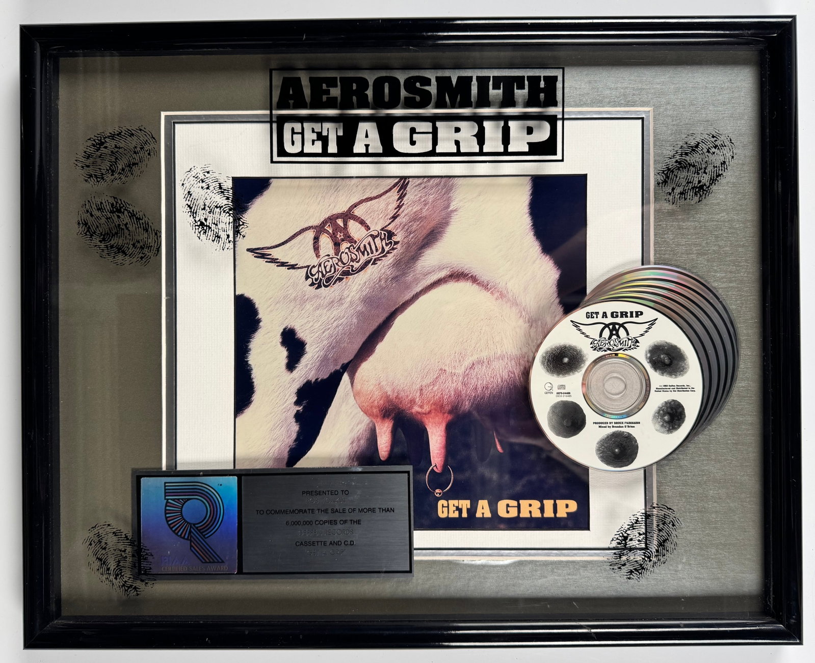 Aerosmith Get A Grip Geffen RIAA Six Million Sales Platinum Record Award Display: Official RIAA-certified multi-platinum sales award commemorating more than 6,000,000 copies sold of Aerosmith's Get A Grip. The custom display features a platinum record, multiple compact discs, signa