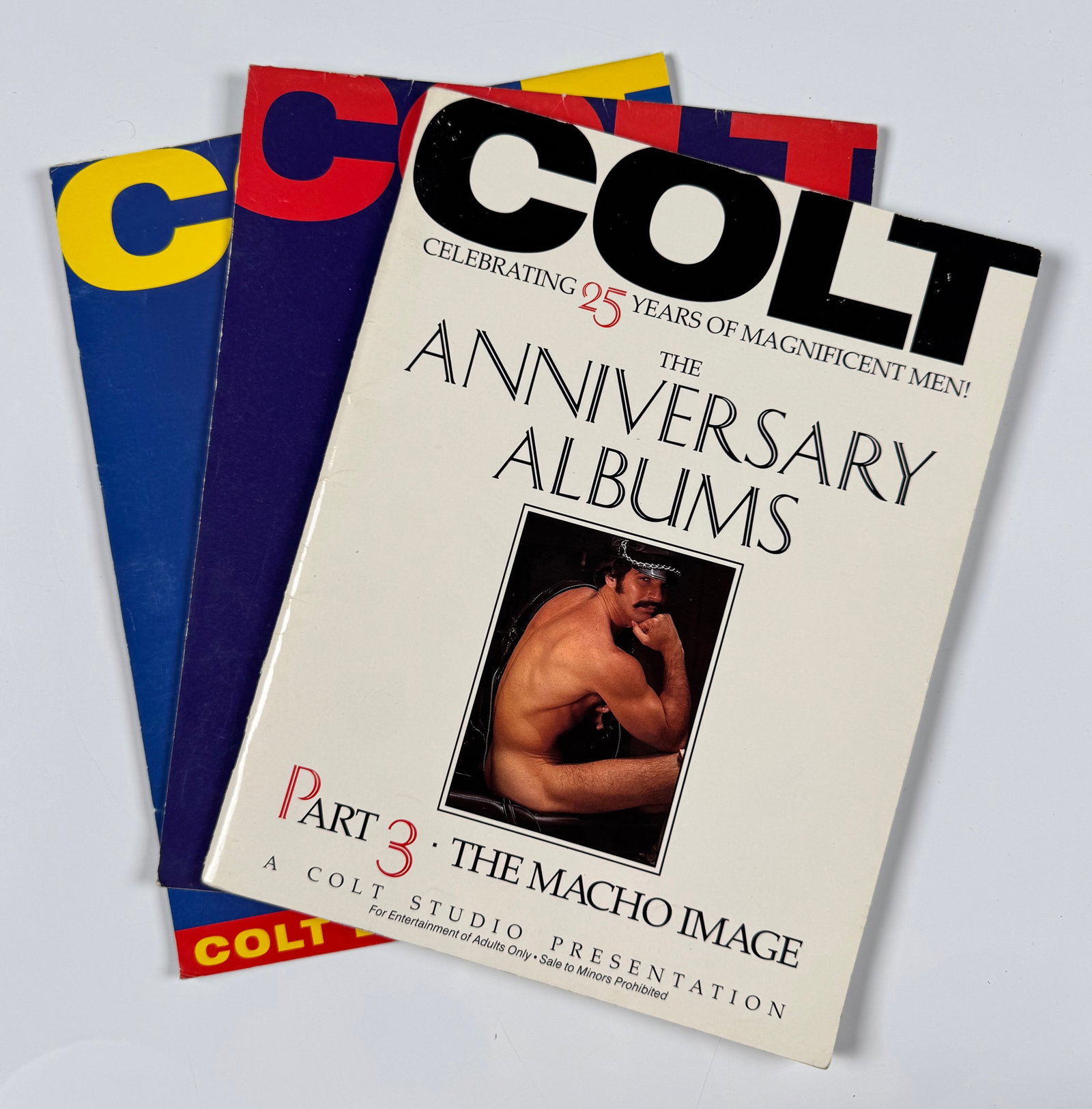 Colt Anniversary Albums Part 3 Magazine 1998 2005 Colt Calendars Gay Nude Male Interest Lot: Lot consisting of Colt Anniversary Albums Part 3: The Macho Image magazine together with one 1998 Colt calendar and one 2005 Colt calendar. Published by Colt Studio and featuring male photography thro