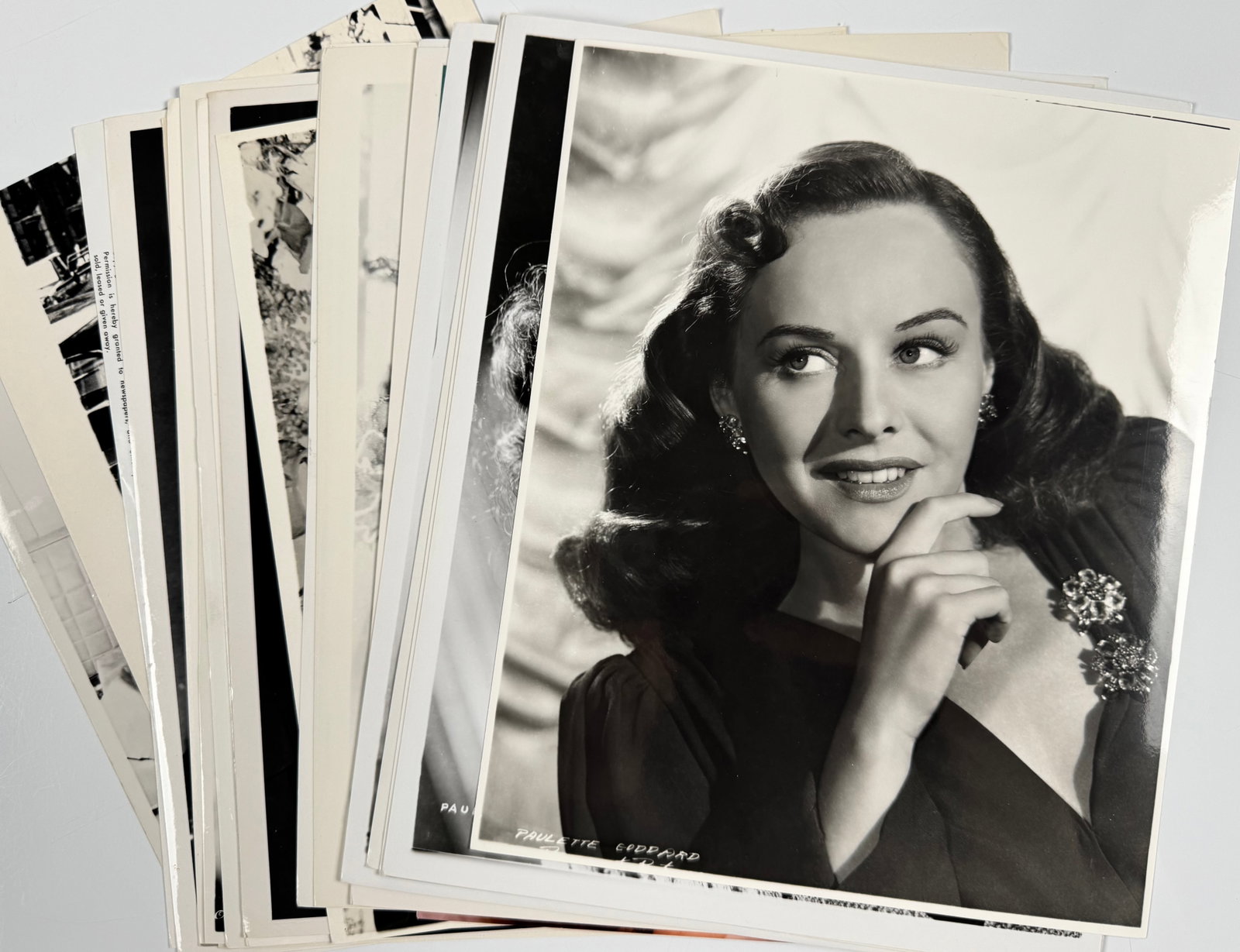 Paulette Goddard Lot of 24 Vintage Hollywood Press Photos Film Stills Publicity Portraits: Lot of 24 black-and-white publicity photographs and film stills featuring Paulette Goddard. Examples include a Paramount portrait with Goddard's name printed in the image and captioned studio stills. 