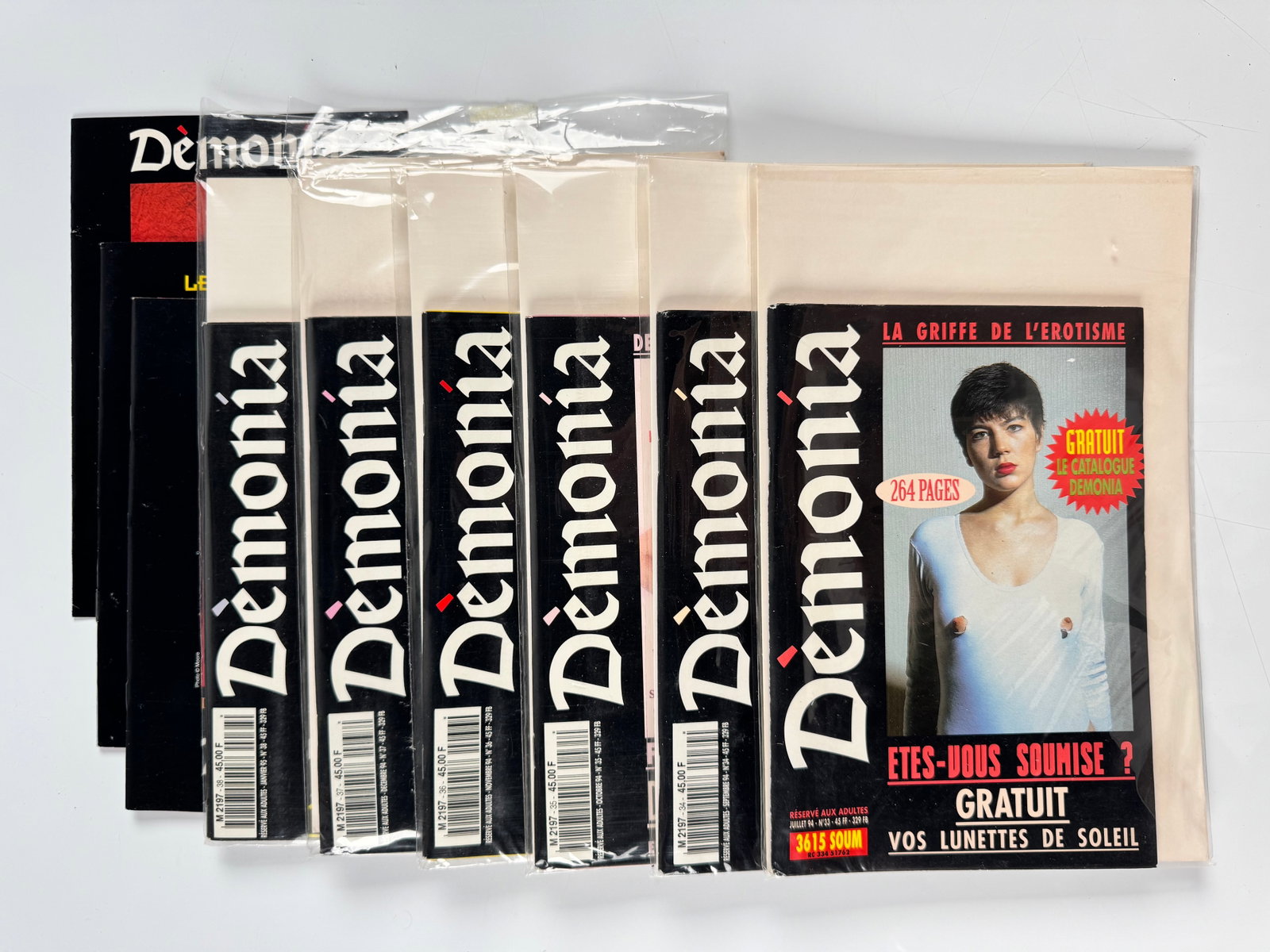 Démonia Nos. 34-38 Paris Comédit French BDSM Fetish Erotica Magazines Catalogue 1994-95 Lot 6: Six-piece group published in Paris by Comédit and Démonia, comprising five consecutive issues: No. 34 from September 1994, No. 35 from October, No. 36 from November, No. 37 from December and No. 38 