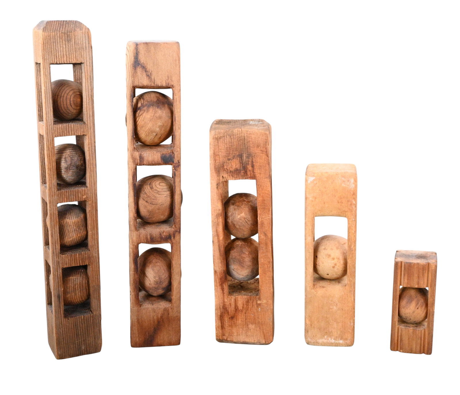 A graduated set of Carved Wooden Ball-in-Cage Whimsies: A graduated set of Carved Wooden Ball-in-Cage Whimsies. A graduated group of hand carved wooden whimsies, each featuring one or more free-floating spheres captured within rectilinear cages. A total