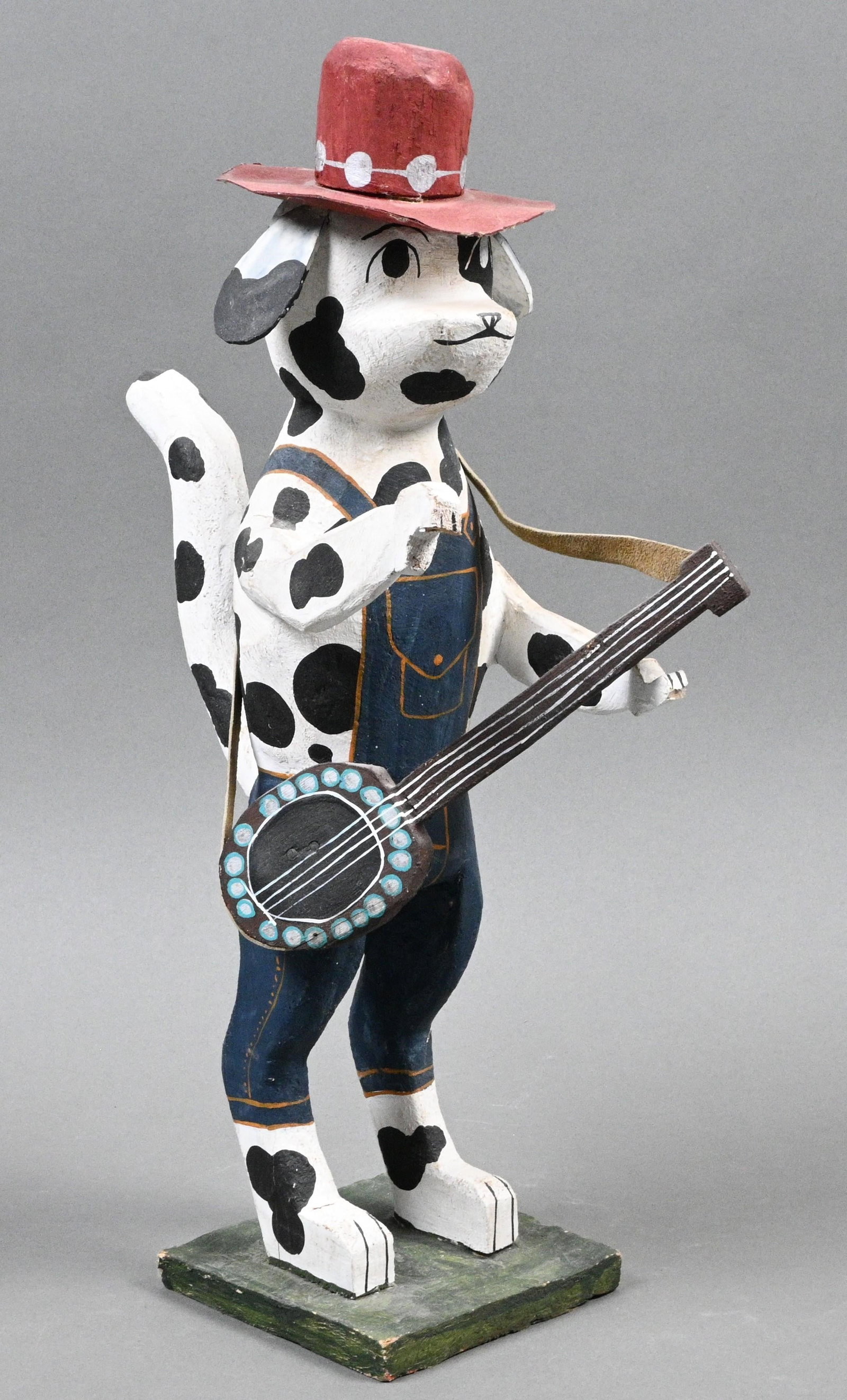 Delbert Buck. Navajo Carved Dalmatian with Guitar: Delbert Buck. (b. 1976) Navajo Carved Dalmatian with Guitar. Signed. Carved and painted wood. Navajo folk artist who lives in New Mexico. Good condition. Some loss under paw. Size: 16.25" h X 4.5" W