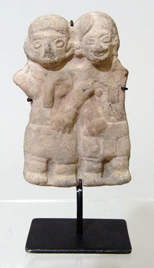 A Tumaco/Tolita erotic effigy depicting both a gri: Colombia, Tumaco/Tolita, c. 200 – 400 AD. An erotic effigy depicting both a grinning male and female couple engaged in erotic petting each holding each other's sexual organs. It is mounted measuring
