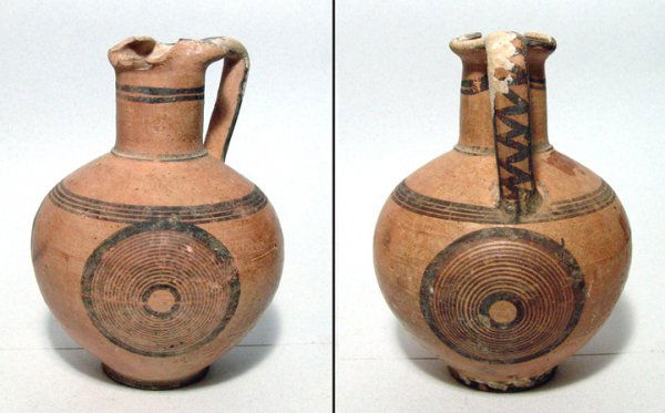 Cyprus, c.8th - 7th Century BC. A small crème buff: Cyprus, c.8th - 7th Century BC. A small crème buff single handled vessel with nice linear decoration in brown. Intact and attractive. H: 4 1/8". See Amiran, Ancient Pottery of the Holy Land, pl. 98 f